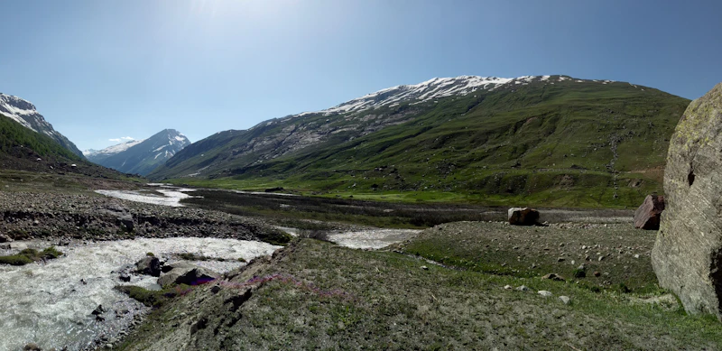 Green mountain valley with a river running through it