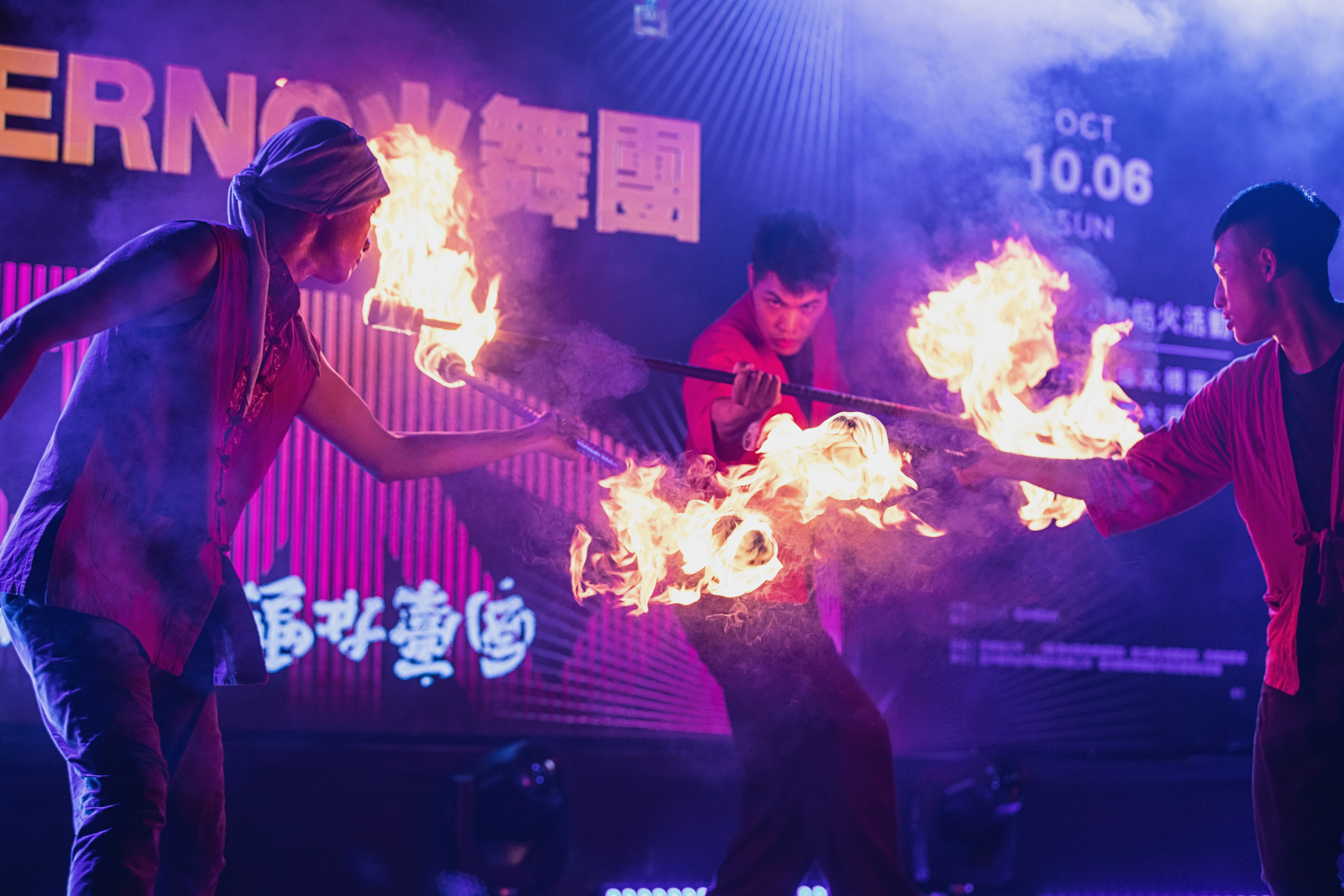 A group of people standing around a fire show