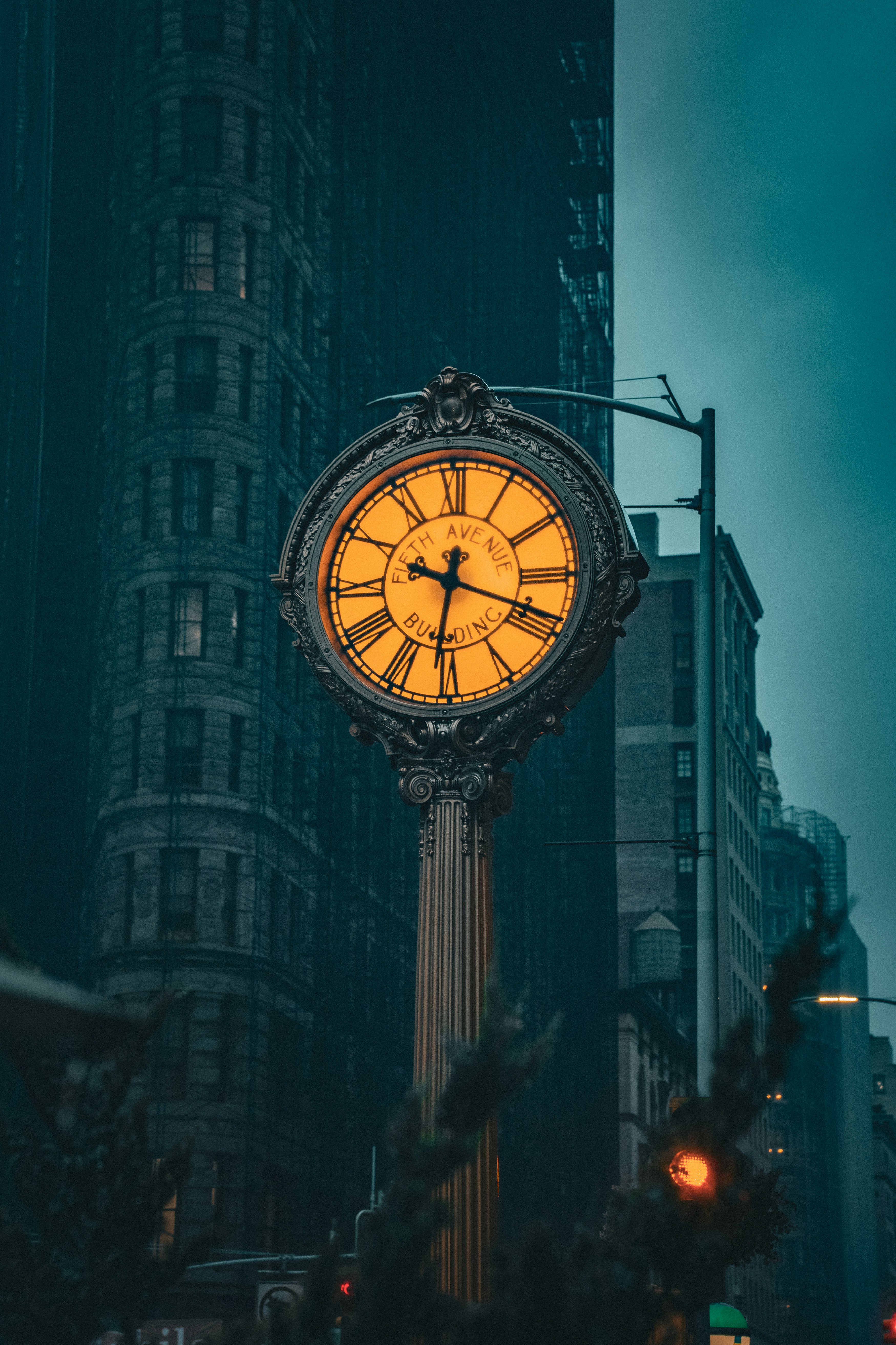 A clock on a pole in the middle of a city