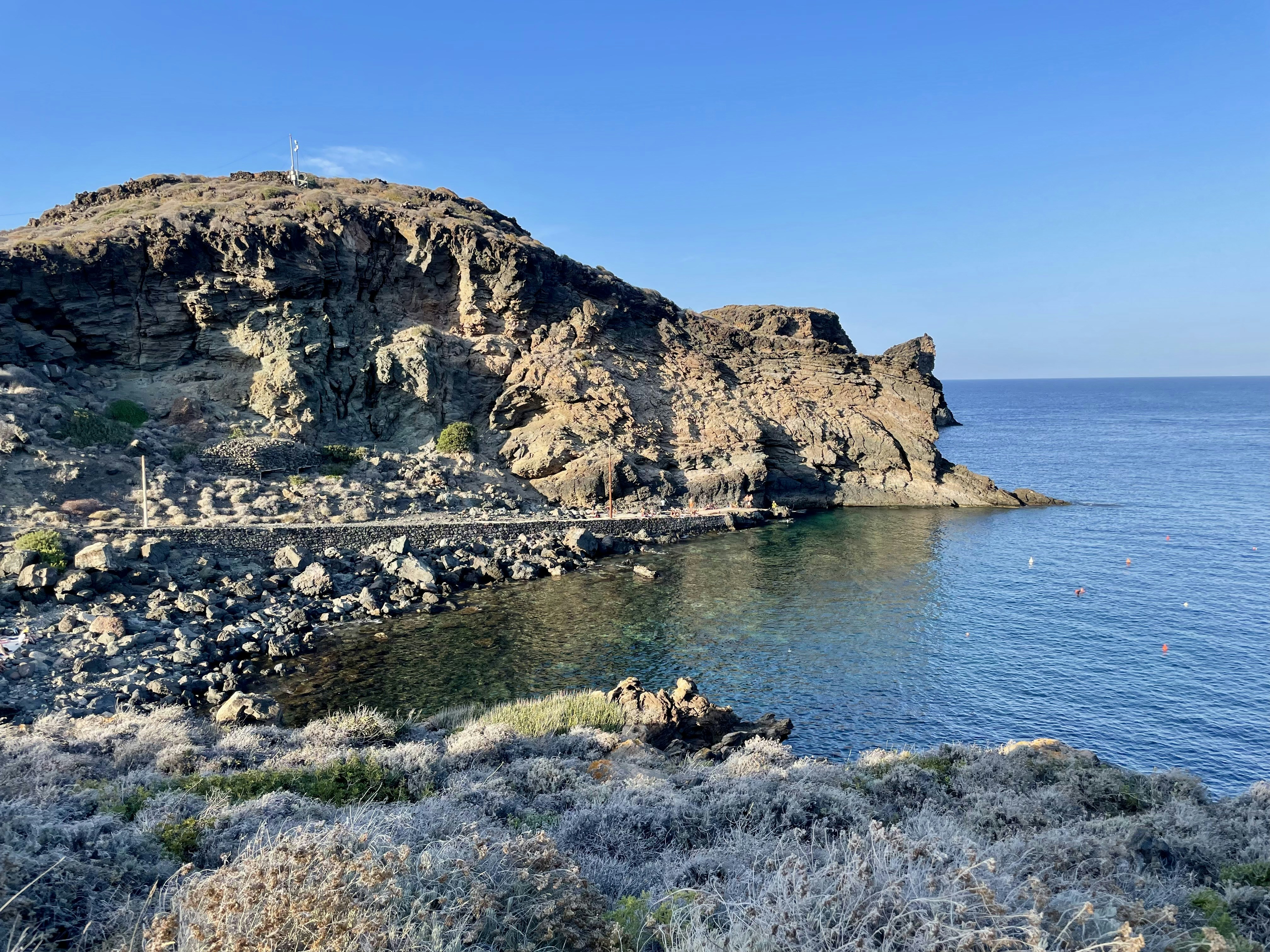 A large body of water sitting next to a rocky shore