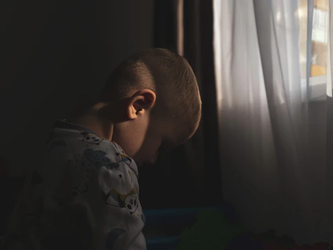 A young boy looking out of a window