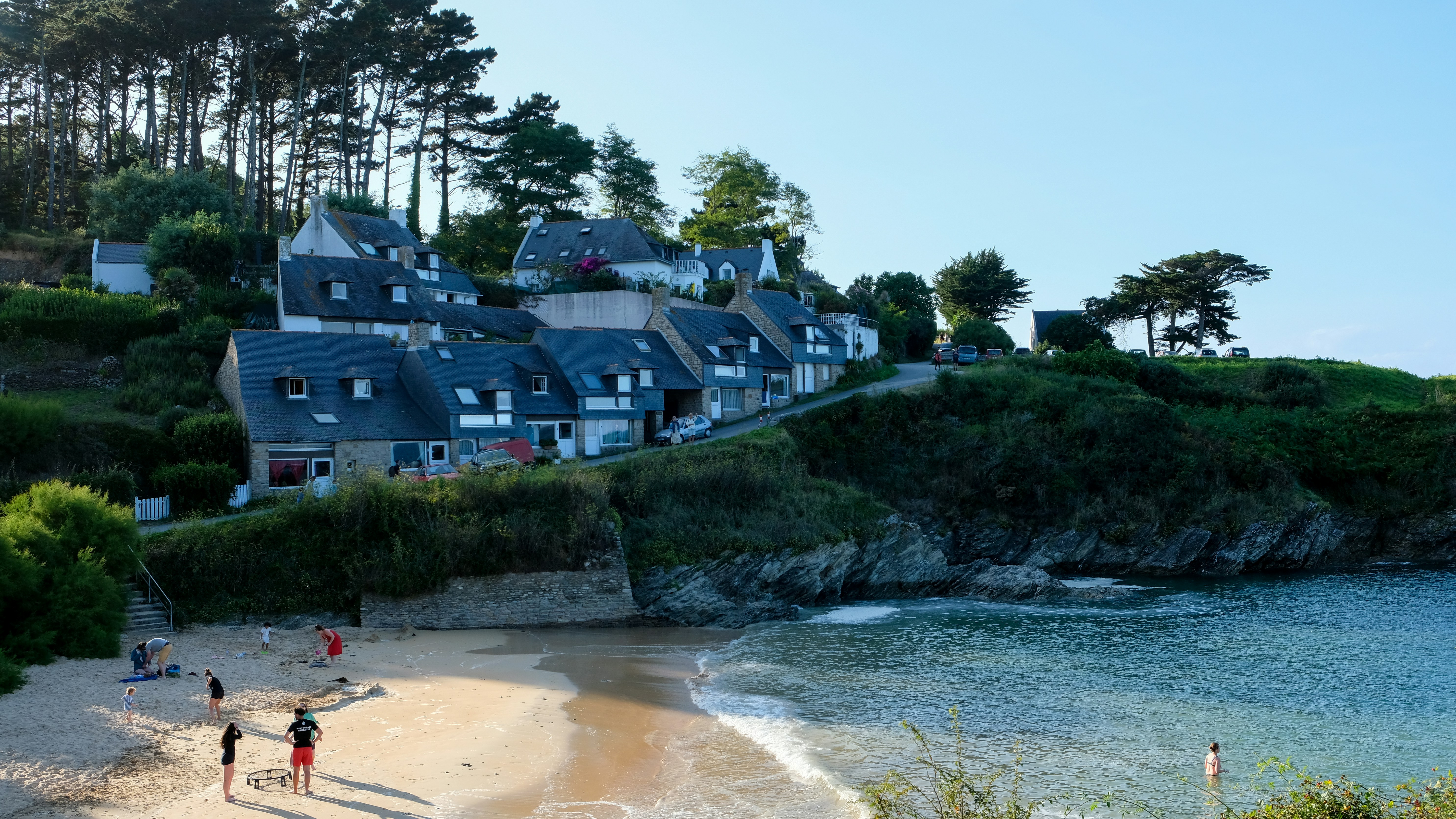 A group of people standing on top of a sandy beach