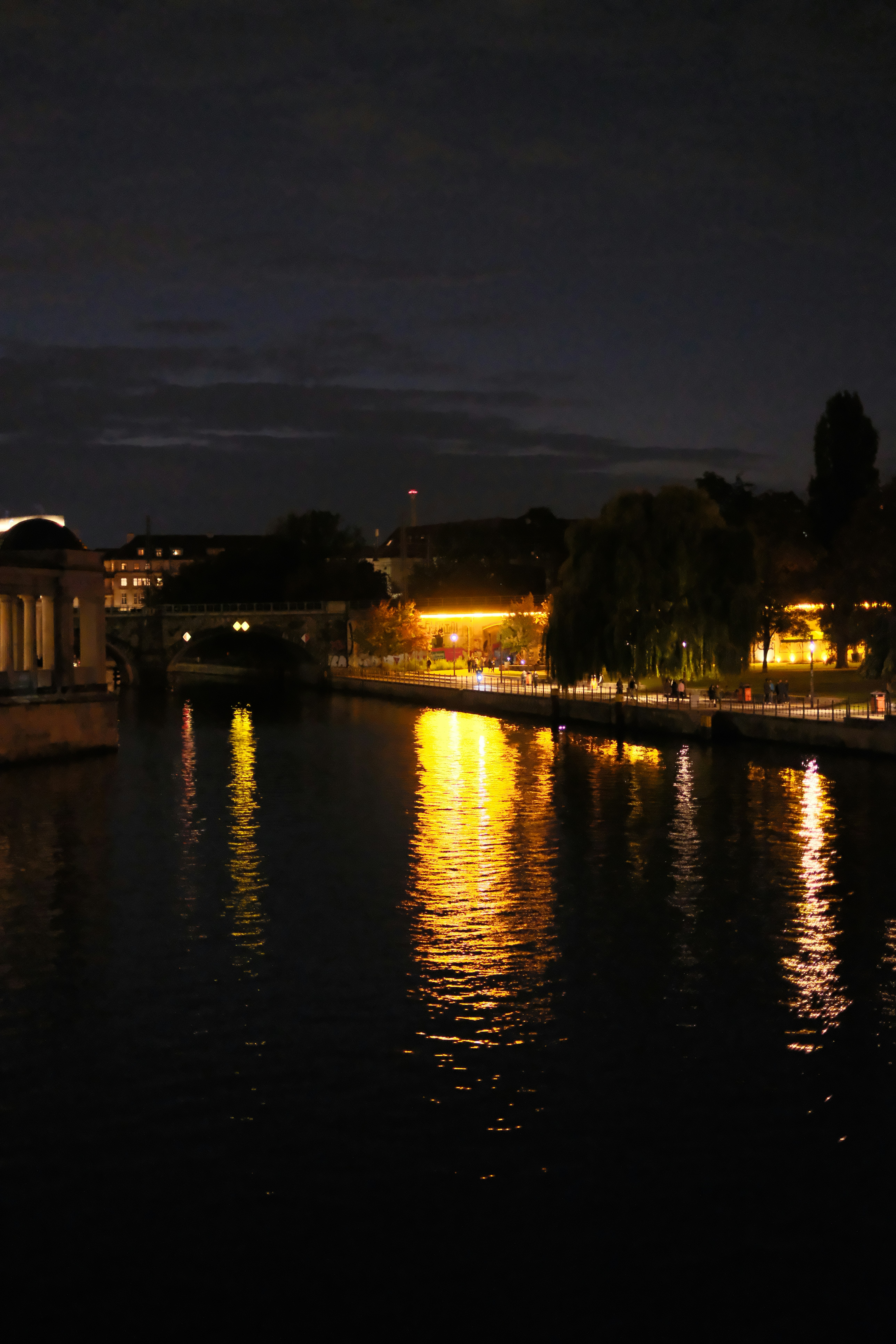 A body of water at night with lights reflecting off the water - a-body-of-water-at-night-with-lights-reflecting-off-the-water-5XuDukF-QdU