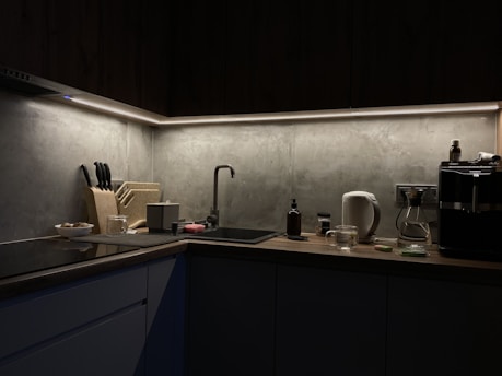 A dimly lit kitchen with a sink and counter