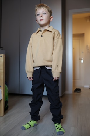 A young boy standing in a living room