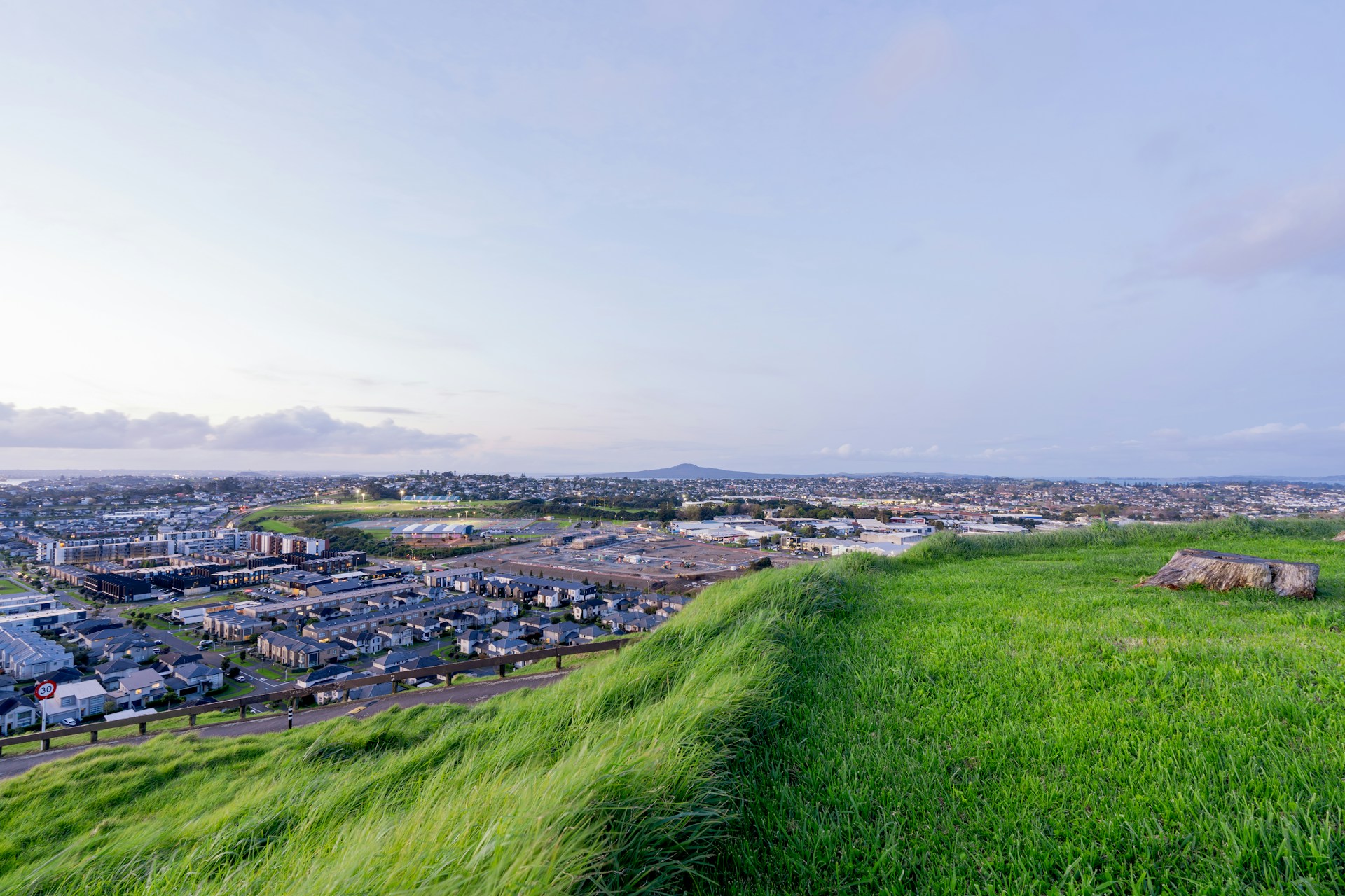 A grassy hill with a city in the background