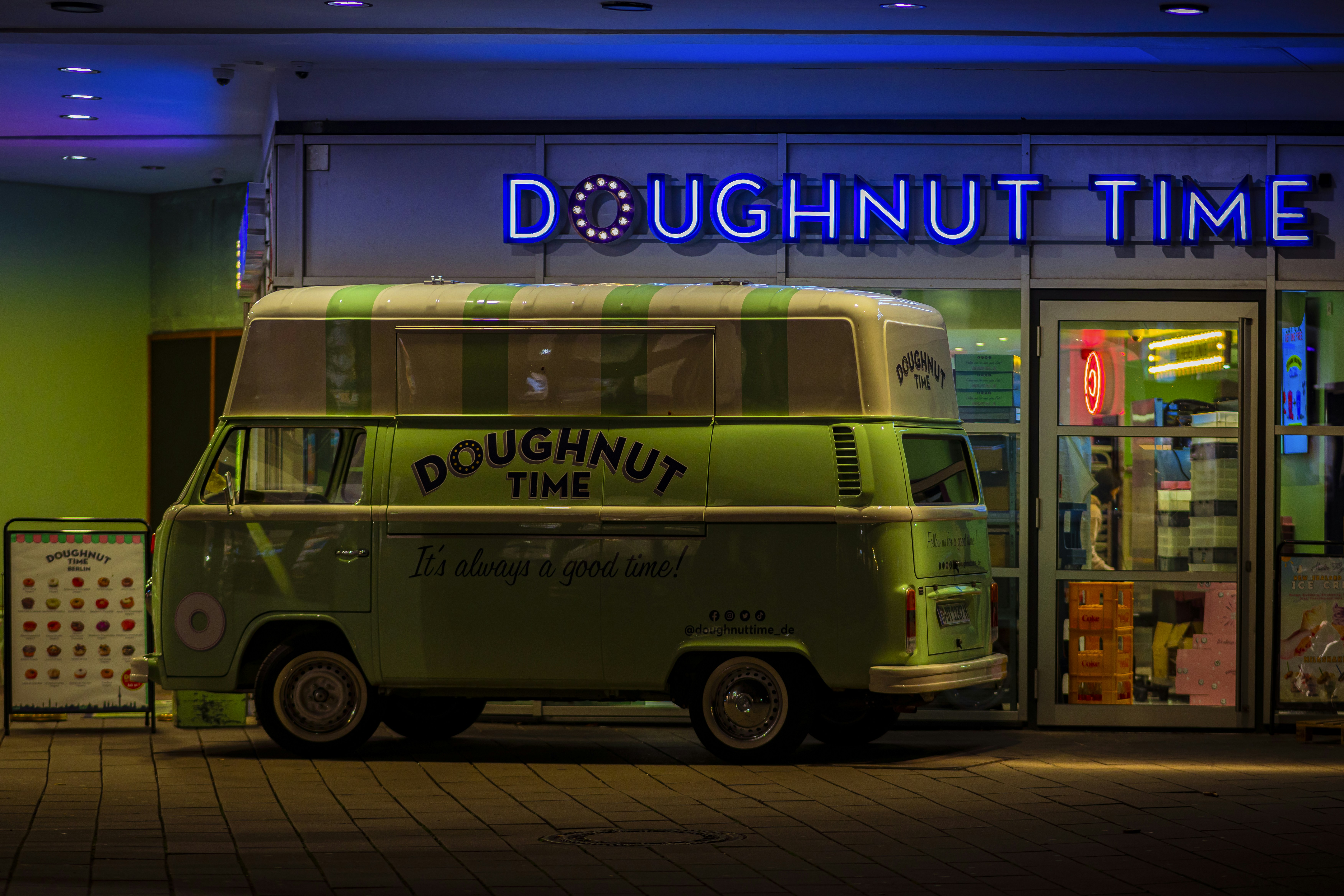 A doughnut time van parked in front of a doughnut shop