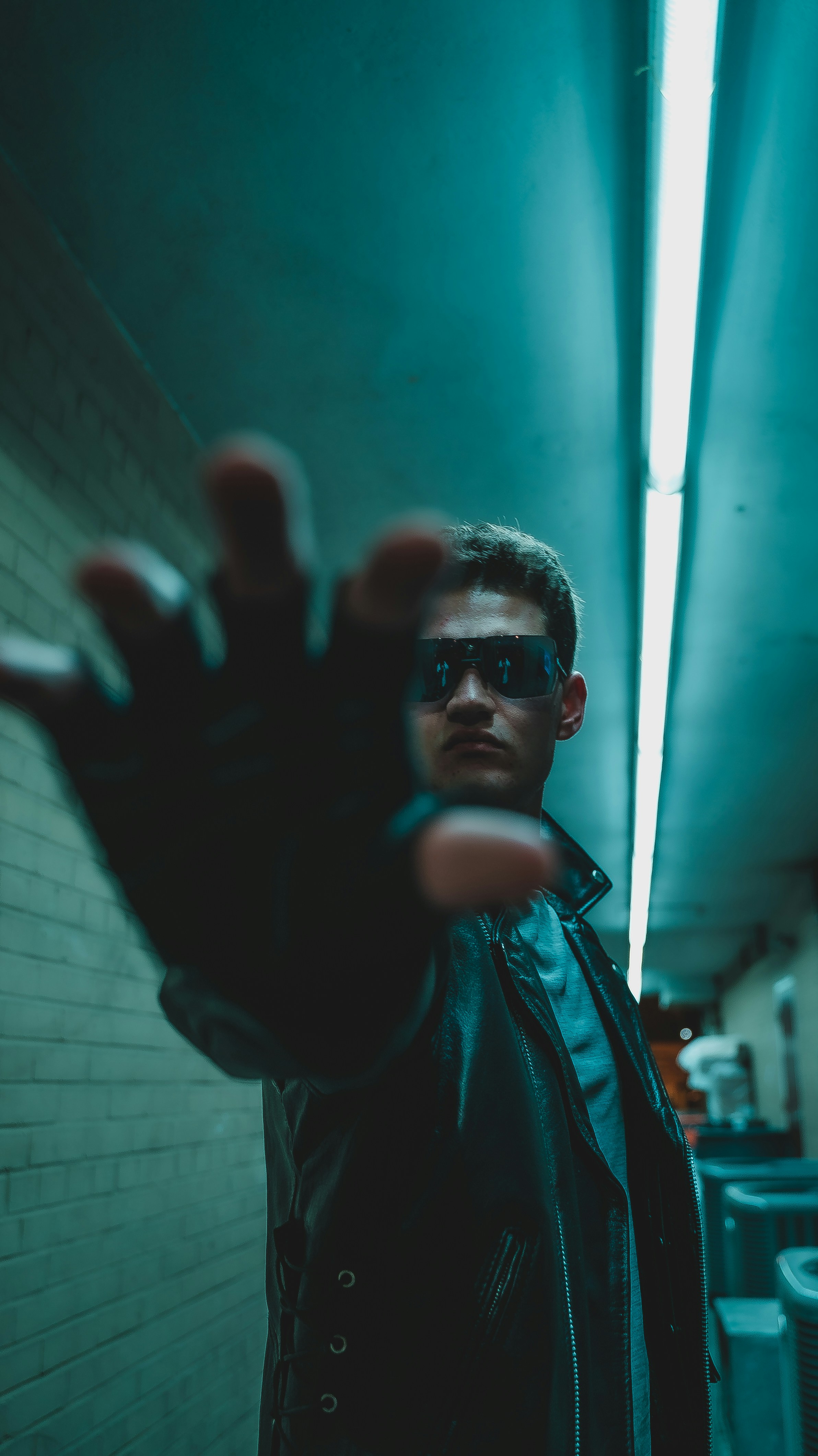 Un hombre con una chaqueta negra levanta la mano