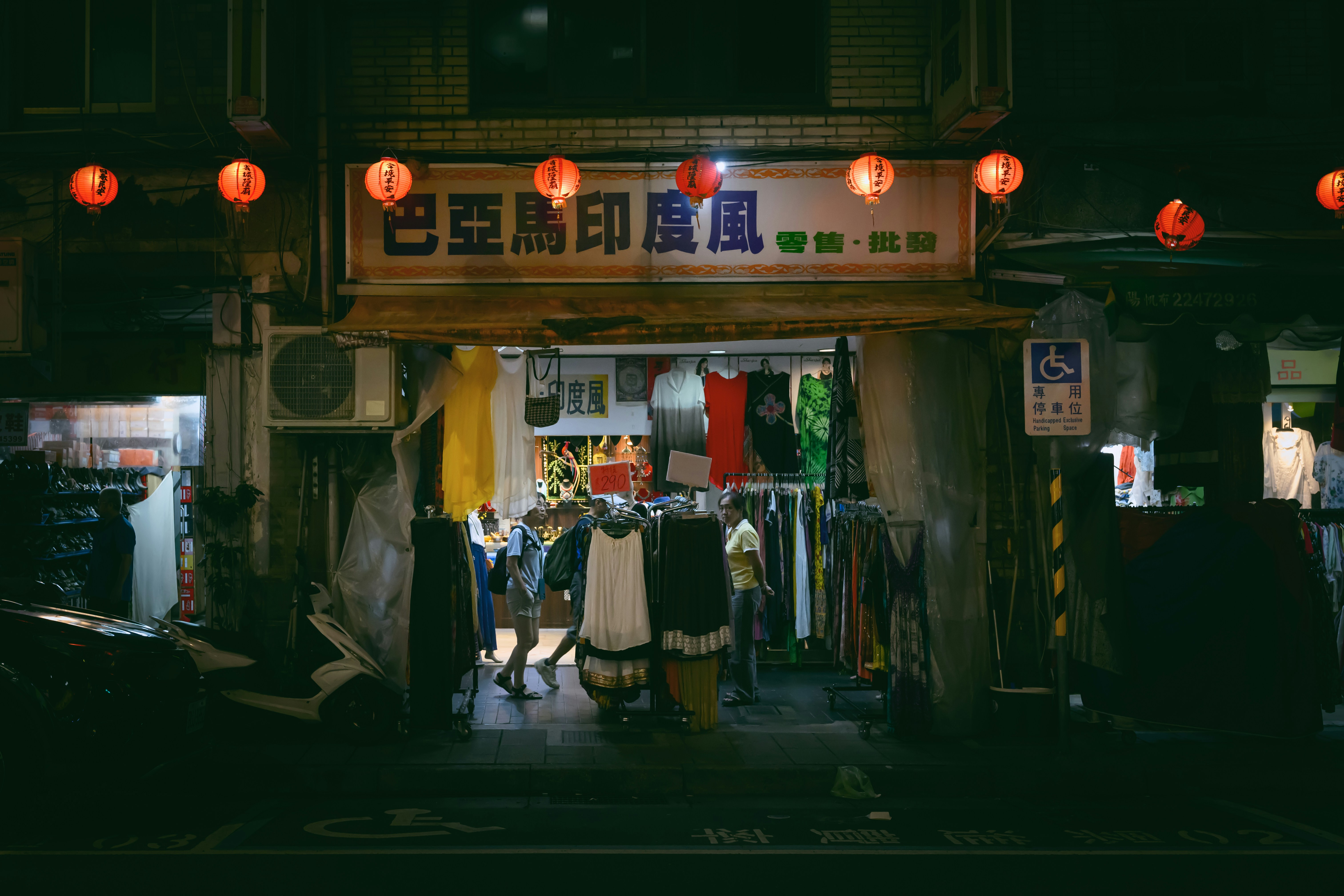 A group of people standing outside of a store at night