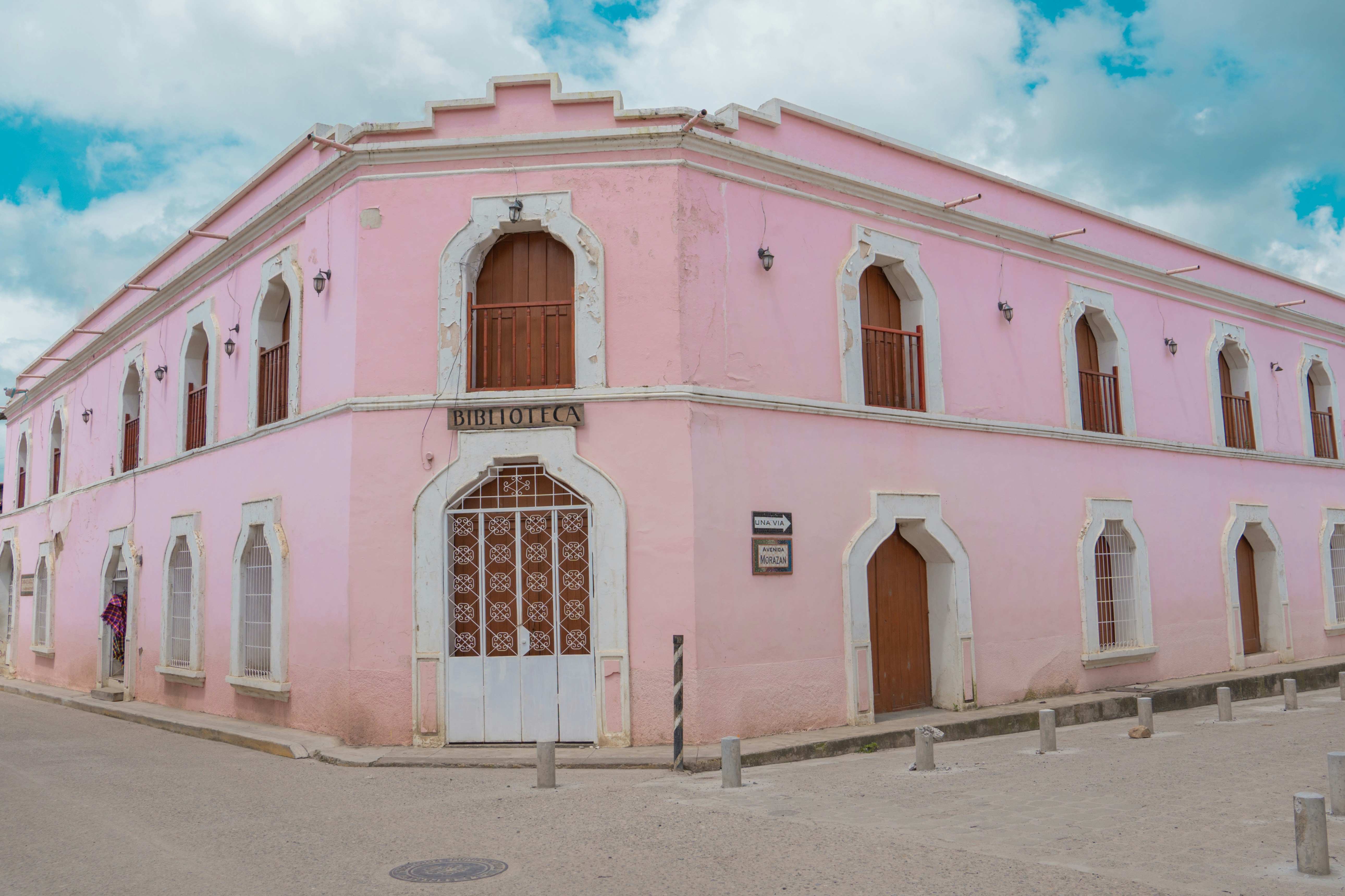 A pink building with a white door and windows