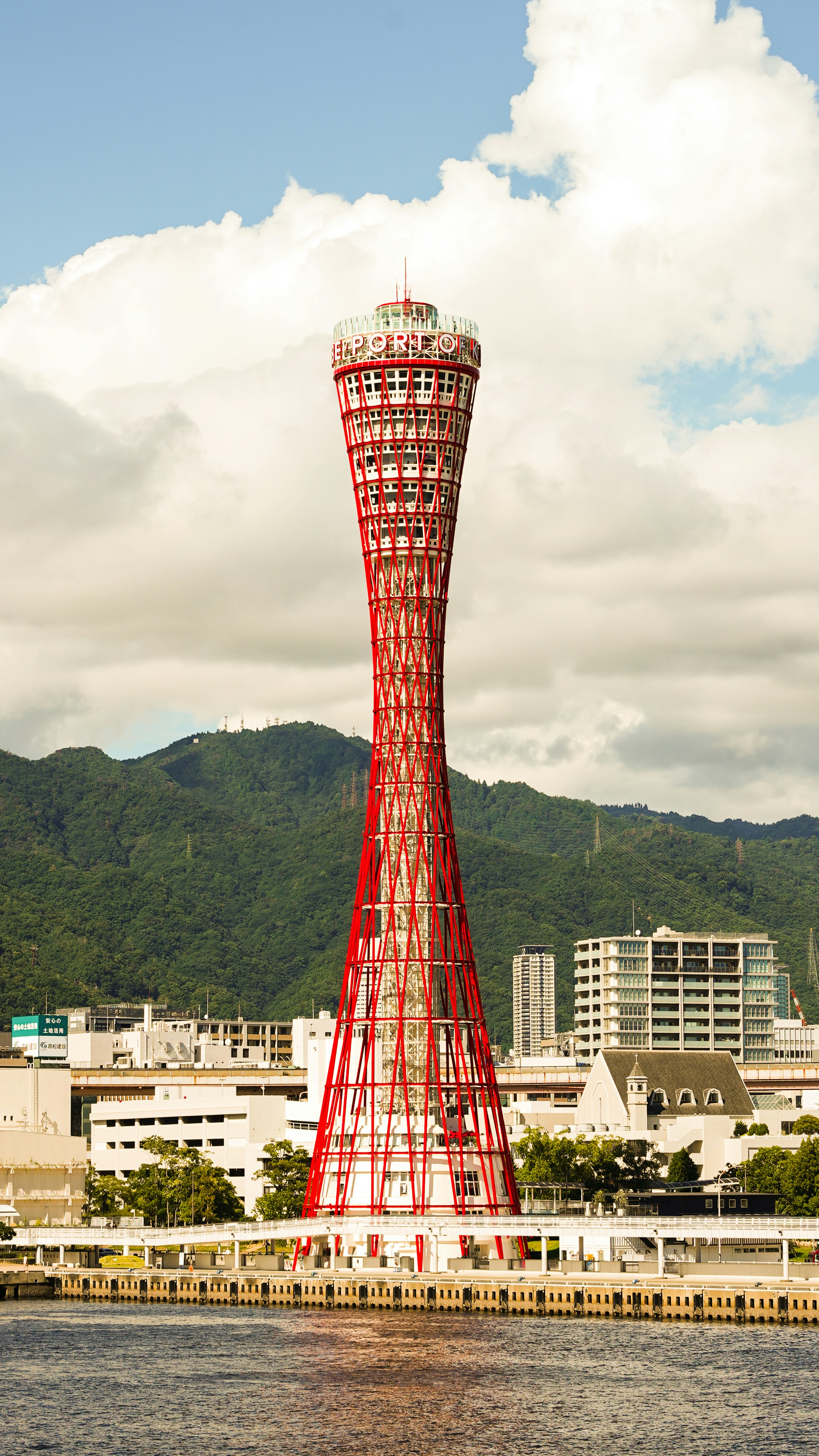 A tall red tower sitting next to a body of water