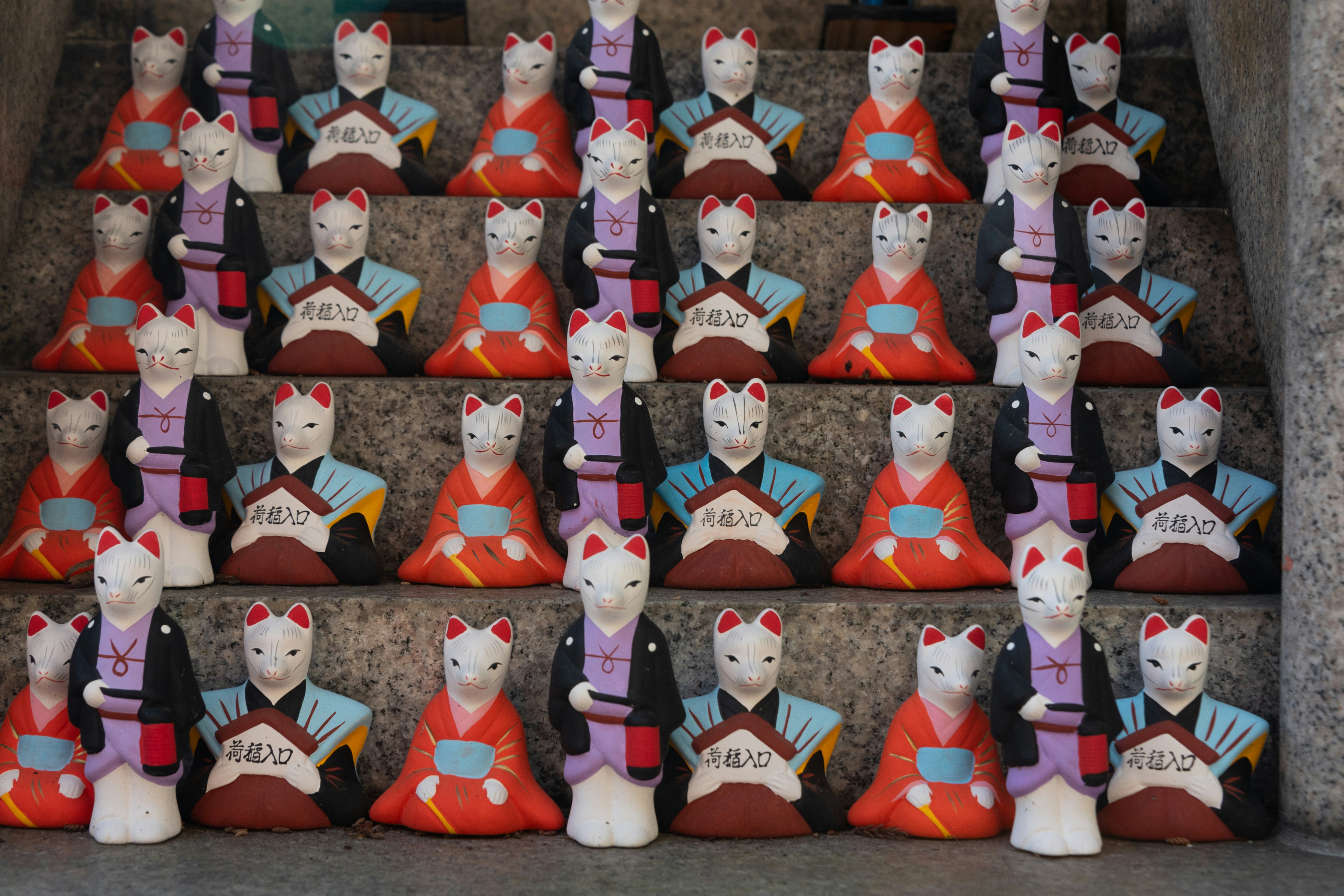 A group of ceramic cats sitting on top of each other