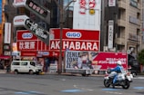 A man riding a motorcycle down a street next to tall buildings