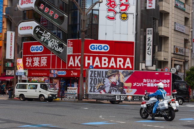 A man riding a motorcycle down a street next to tall buildings