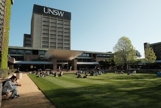 A group of people sitting on top of a lush green field