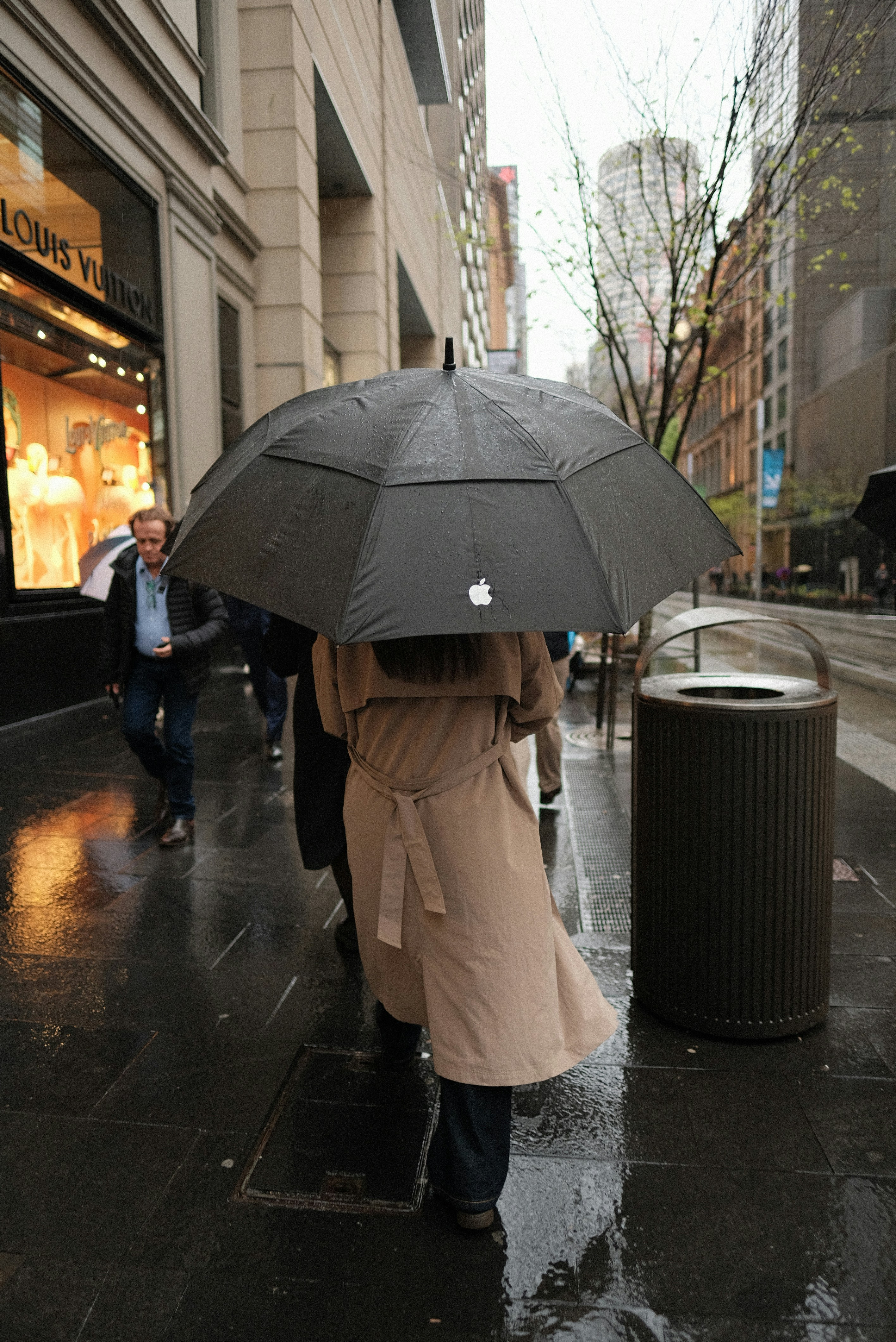 A woman walking down a street holding an umbrella