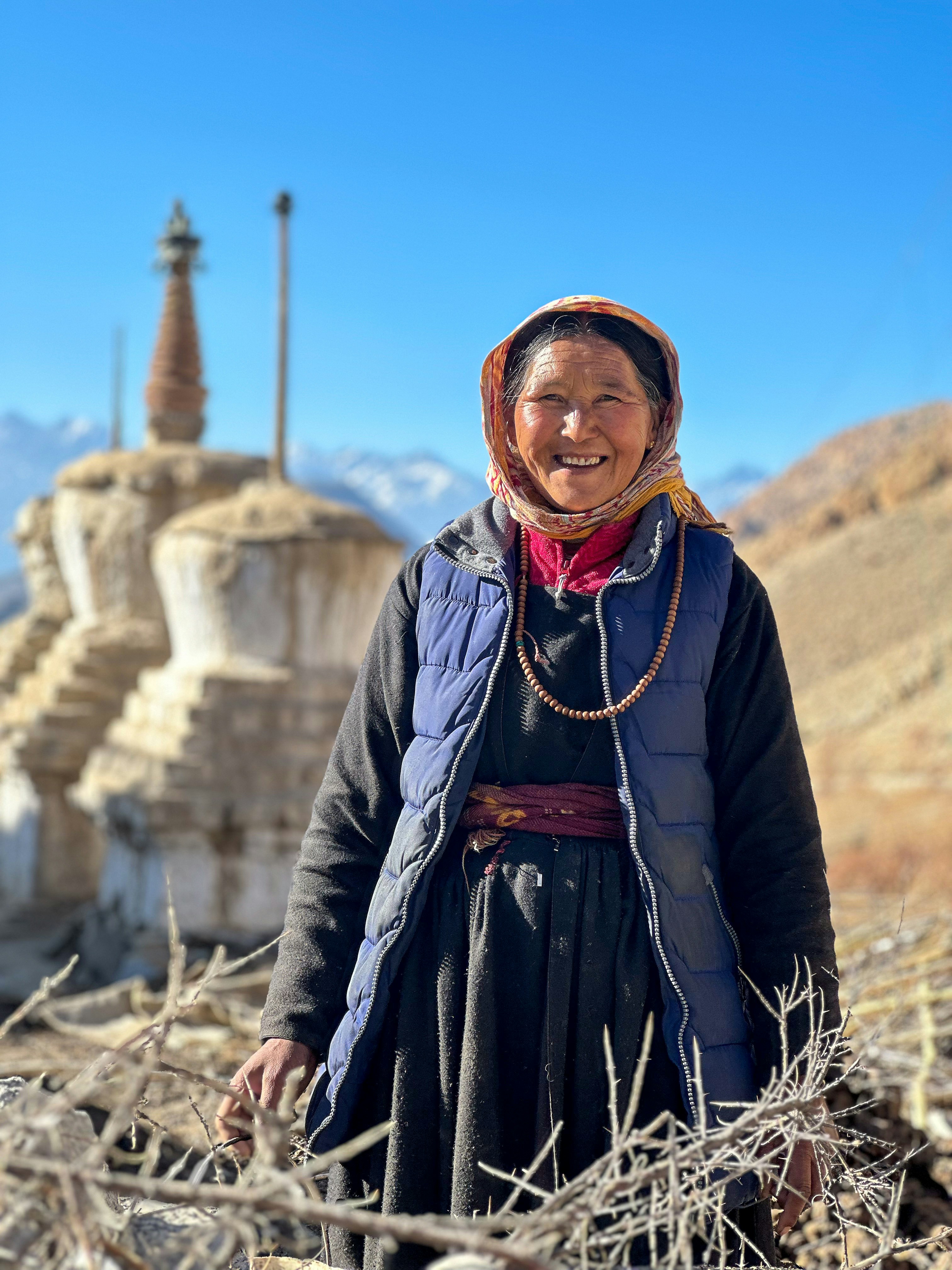 A woman standing in a field with mountains in the background