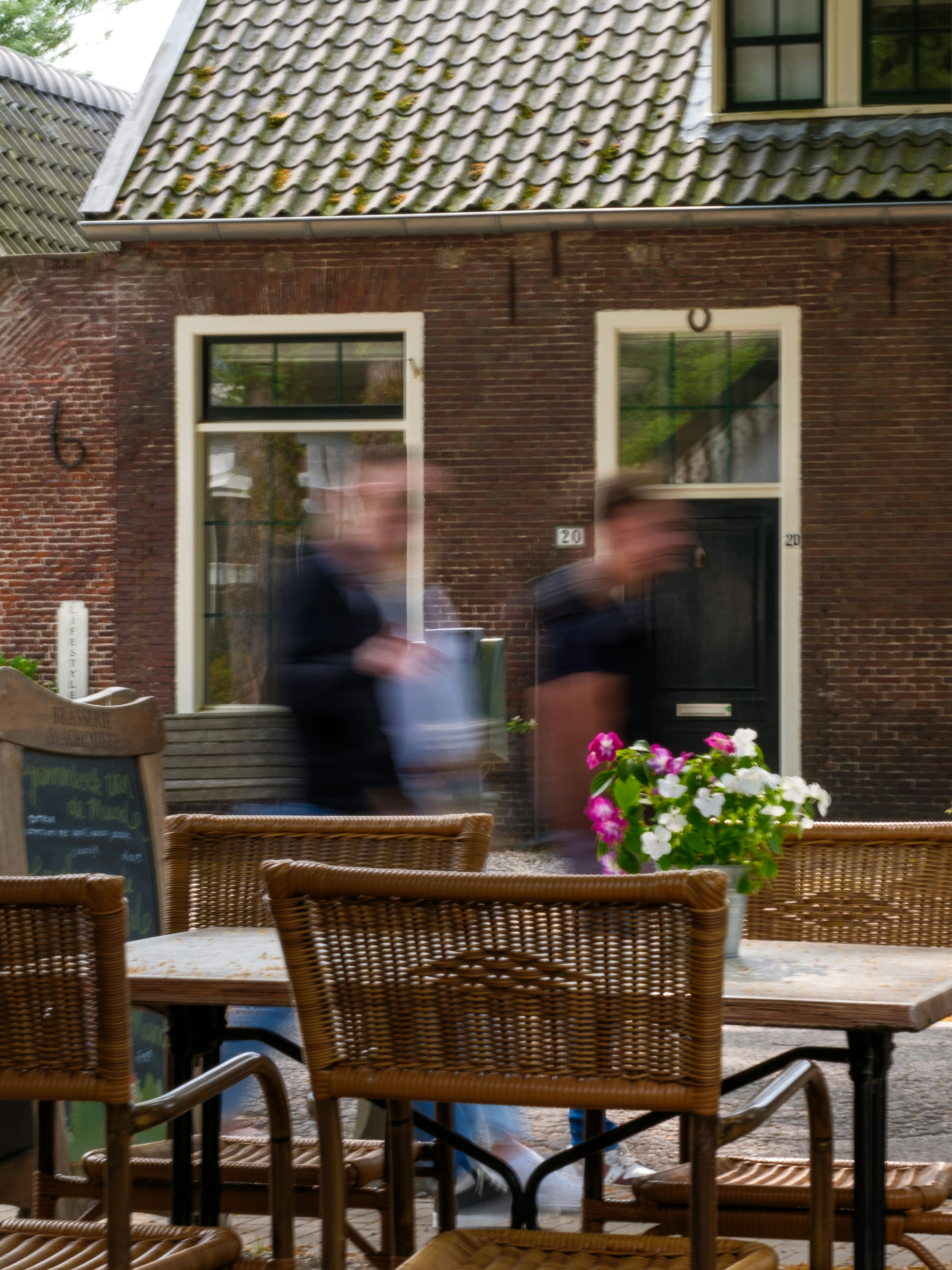 A group of people sitting at a table outside of a house