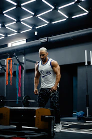 A man standing in a gym holding a barbell