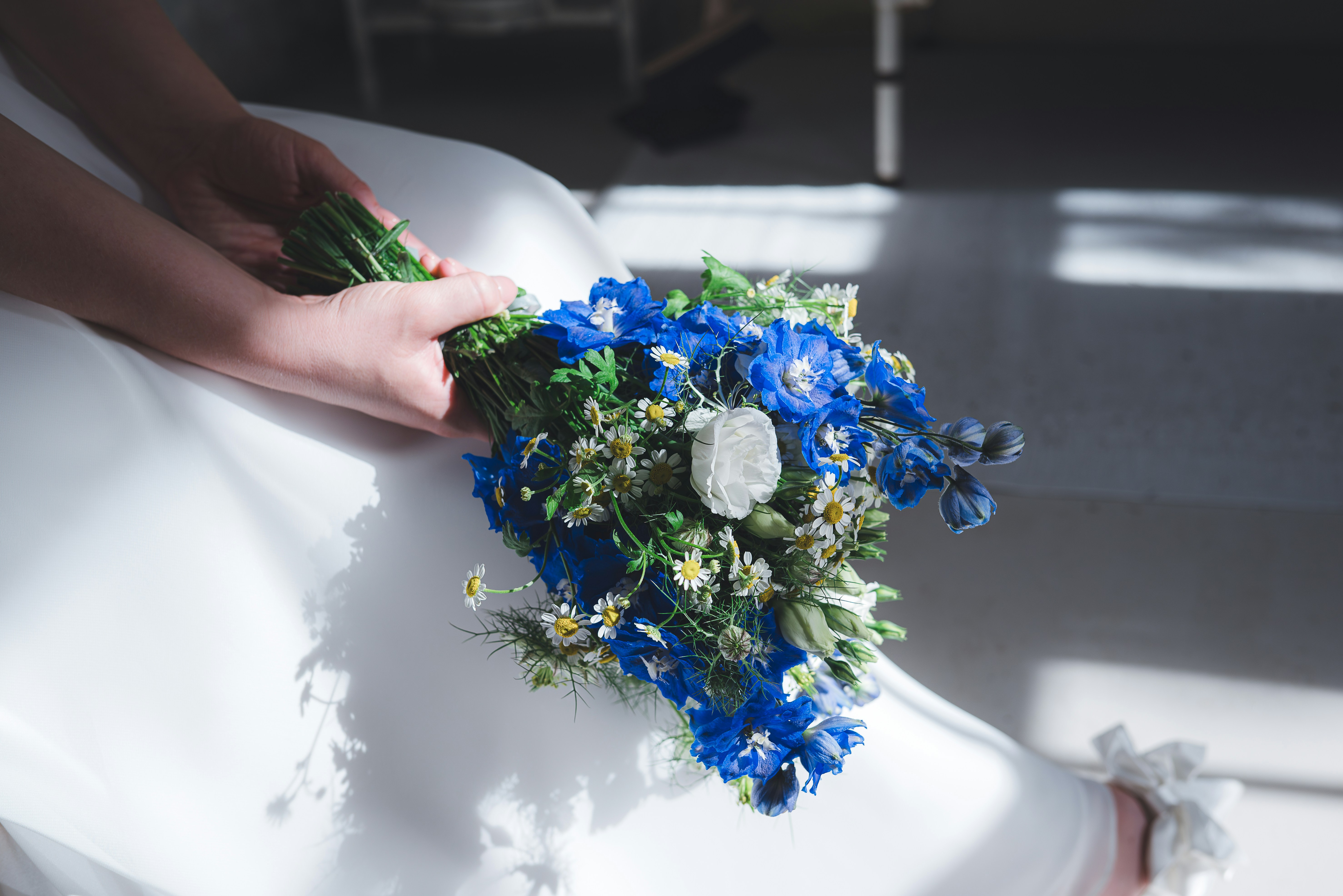 A bride holding a bouquet of blue and white flowers