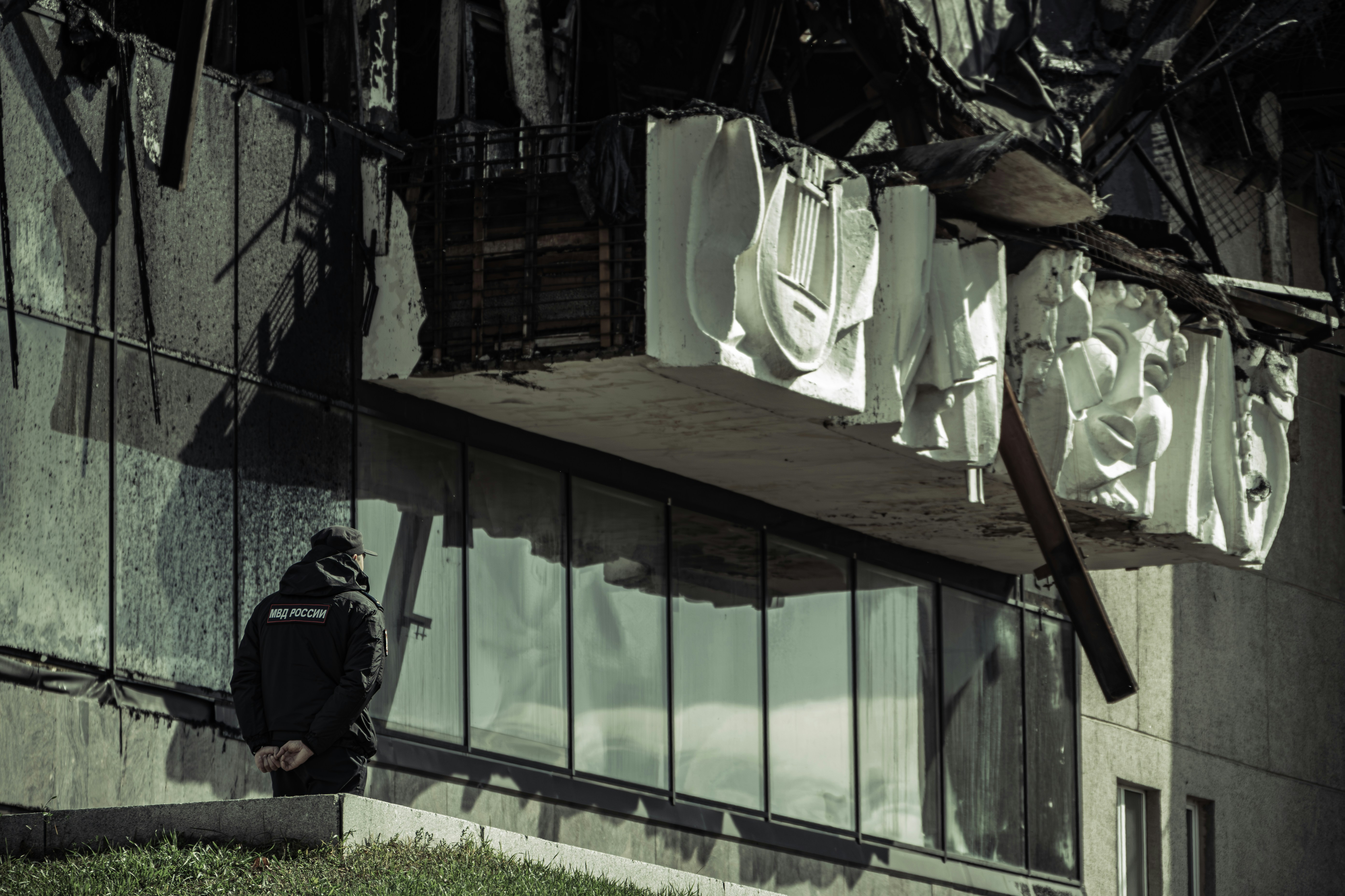A man sitting on a ledge in front of a building