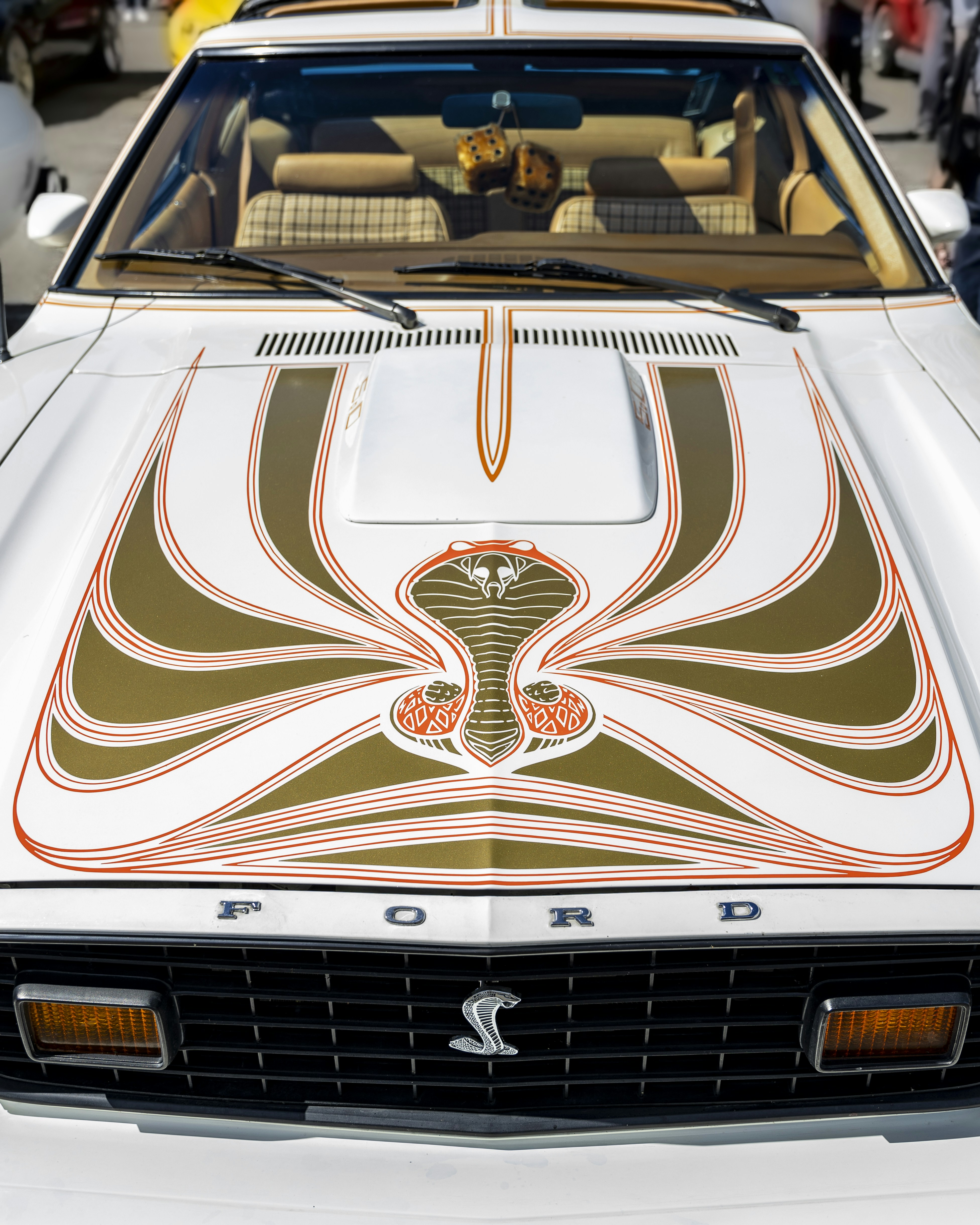 A white car parked in a parking lot next to other cars