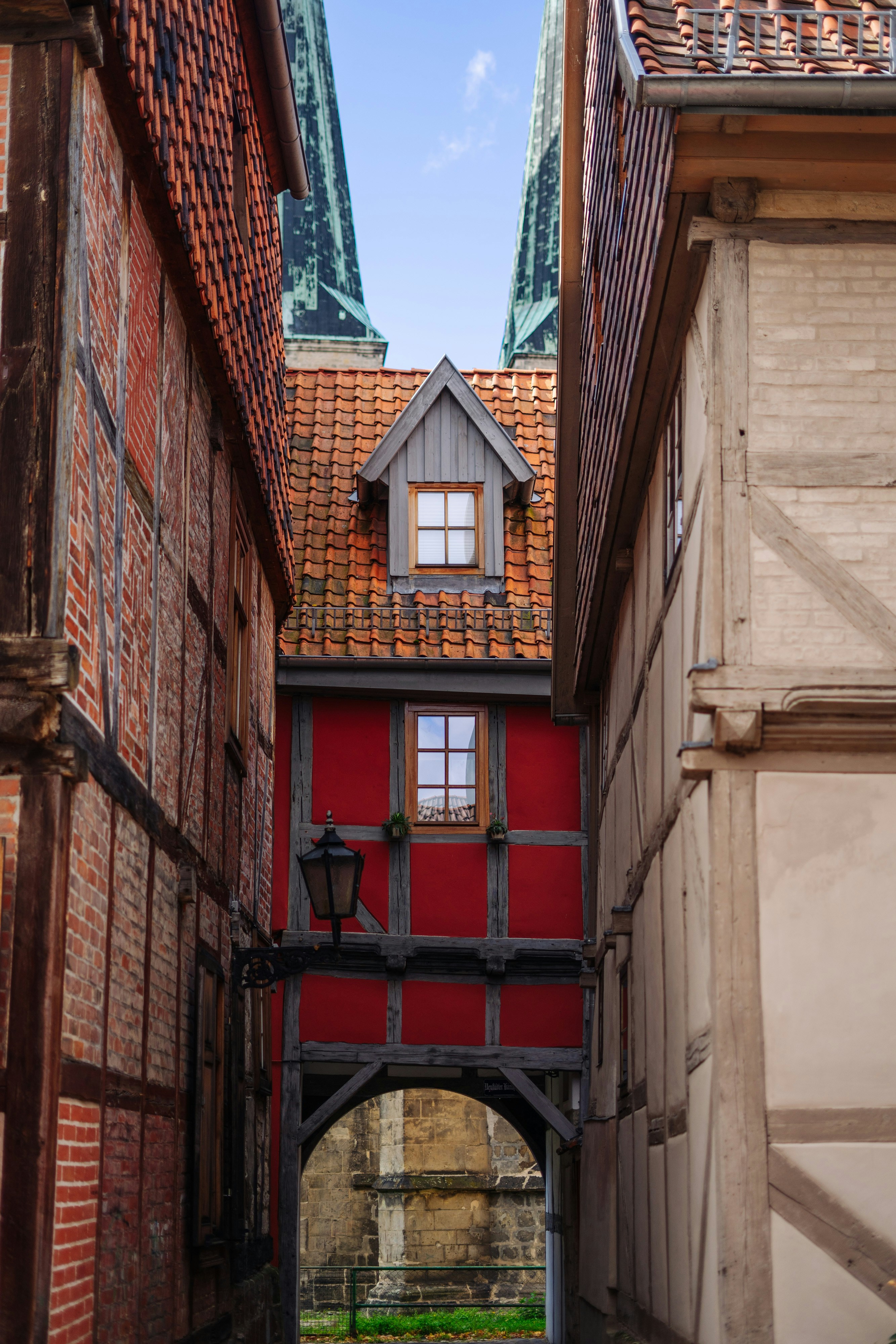A narrow alley way with a red building in the background