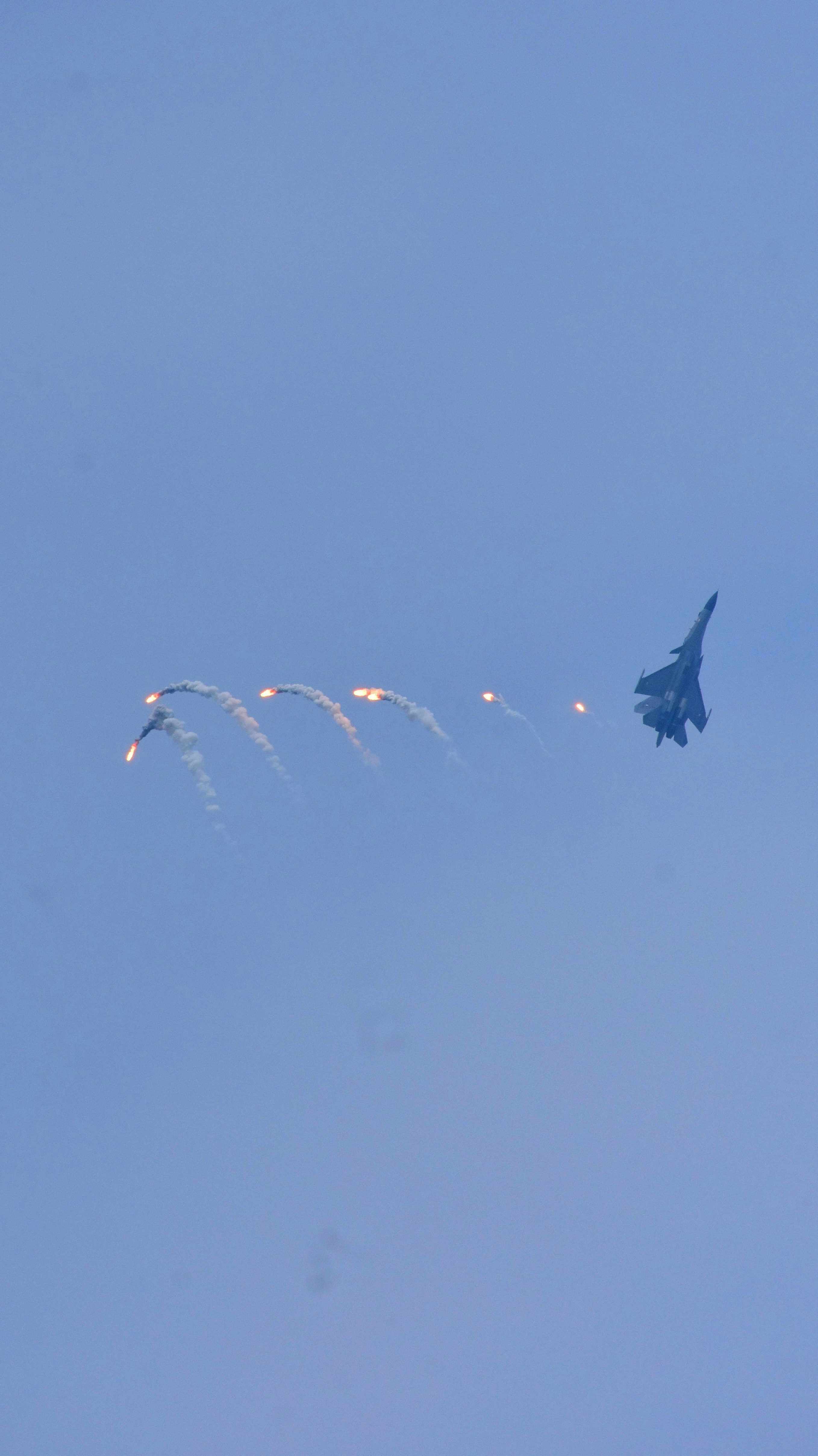 A fighter jet flying through a blue sky