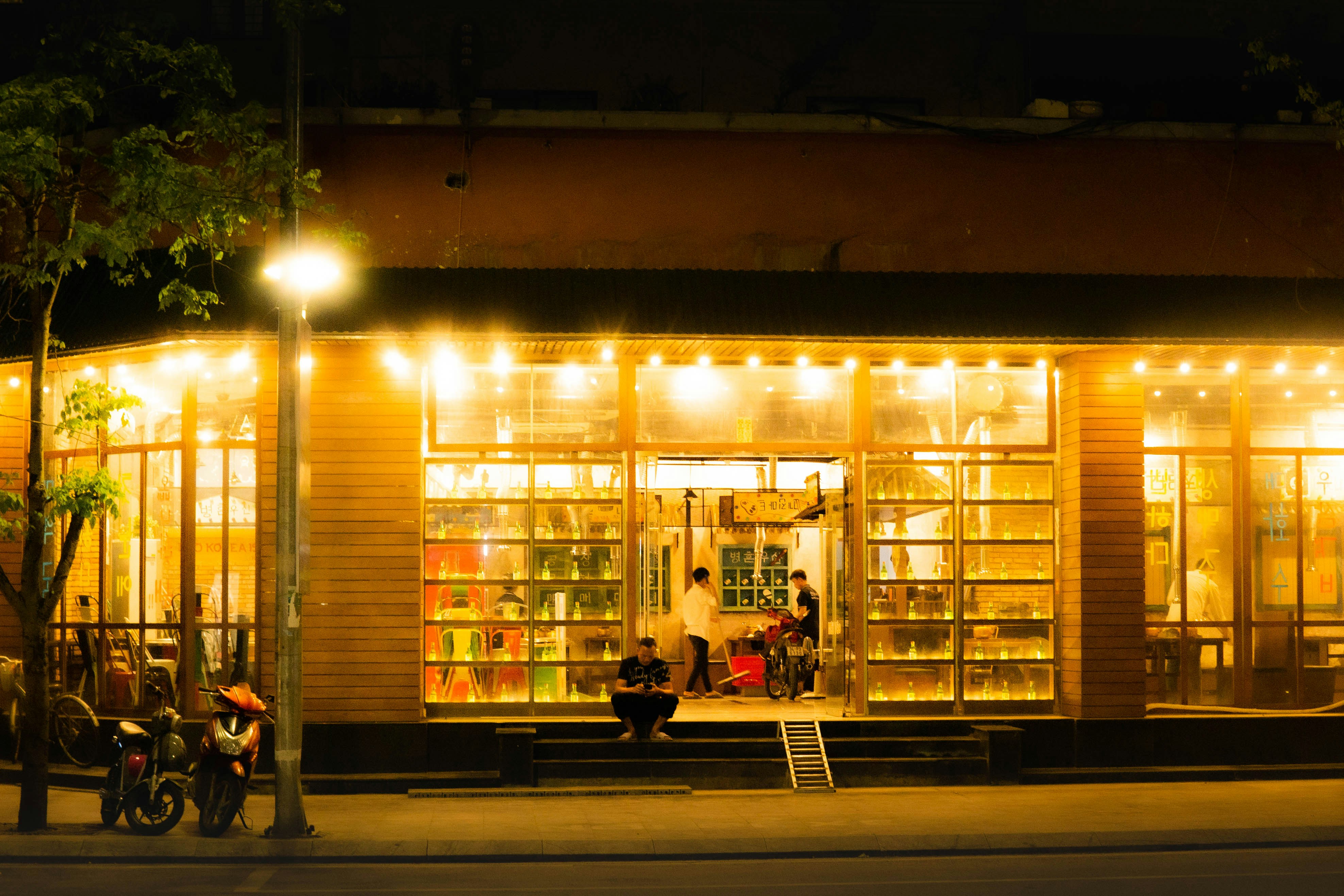 A couple of people sitting on a bench outside of a building
