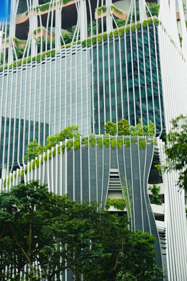 A very tall building with a bunch of trees in front of it