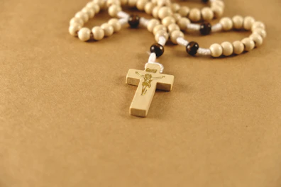 A rosary with a wooden cross on it