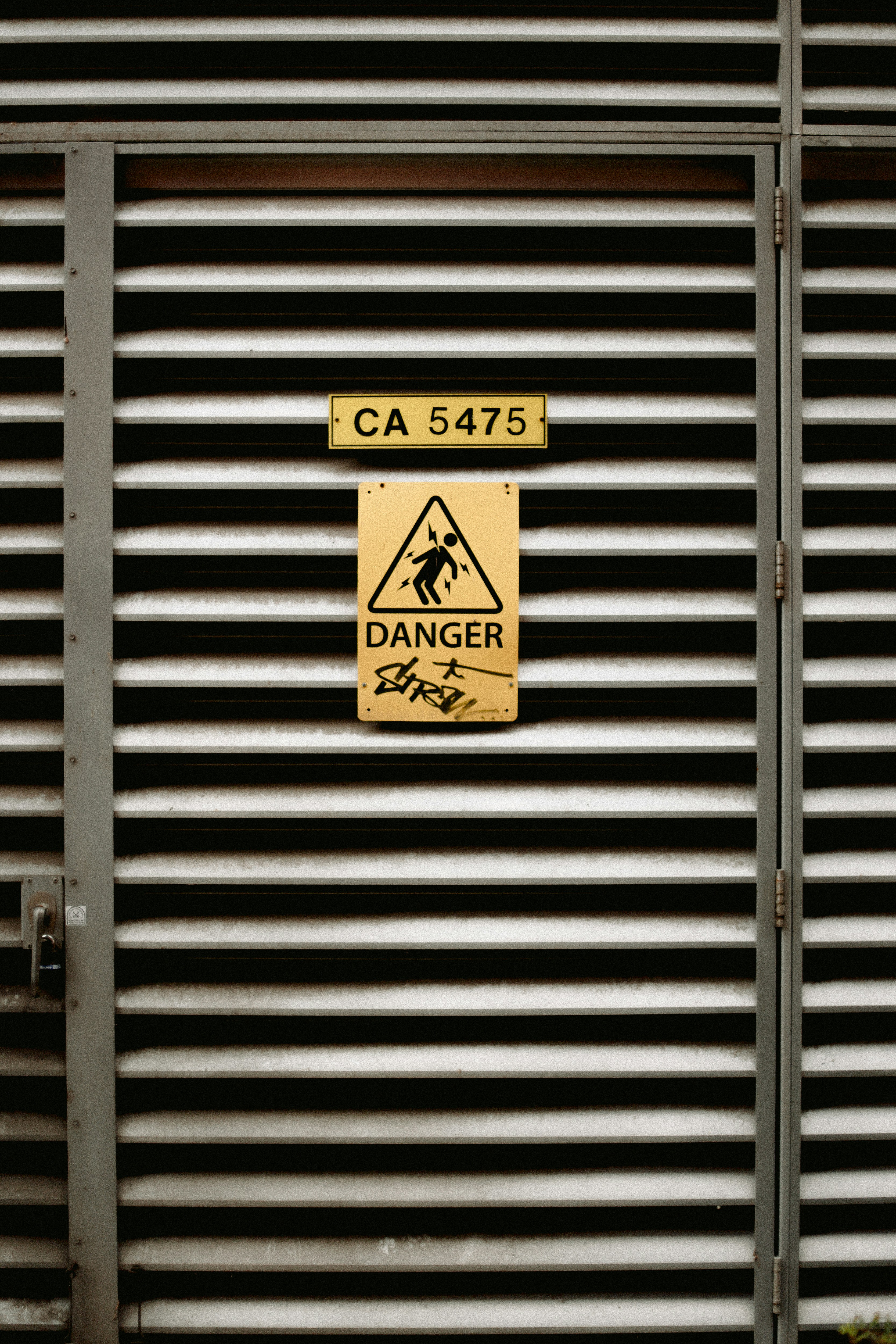 A metal door with a danger sign on it