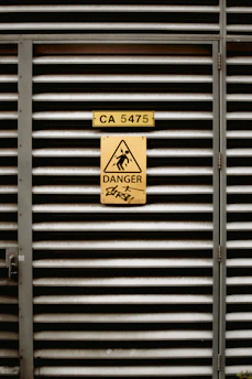 A metal door with a danger sign on it