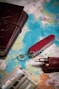 A red pocket knife and a wallet on a map