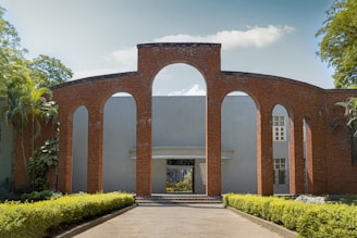 A brick building with arches and a walkway leading to it
