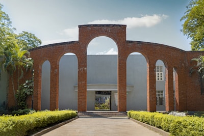 A brick building with arches and a walkway leading to it