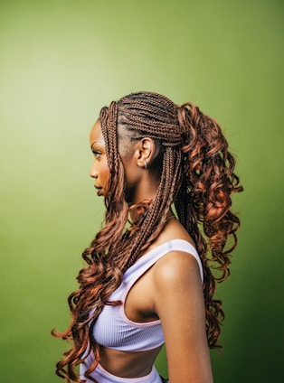 A woman with long braids standing in front of a green wall