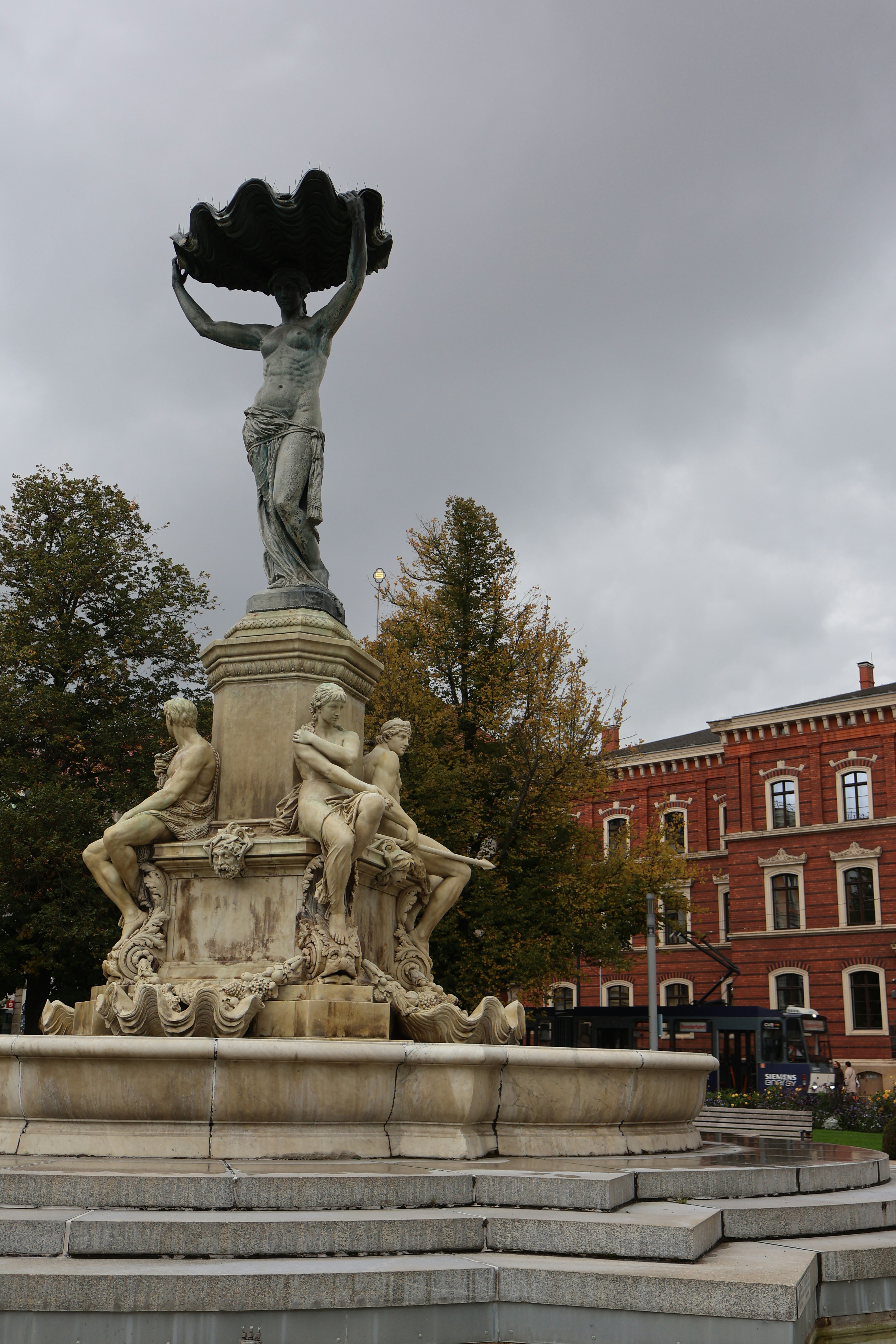 A statue of a woman holding a vase in front of a building