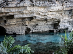 A cave with a pool of water in the middle of it