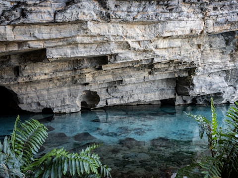 A cave with a pool of water in the middle of it