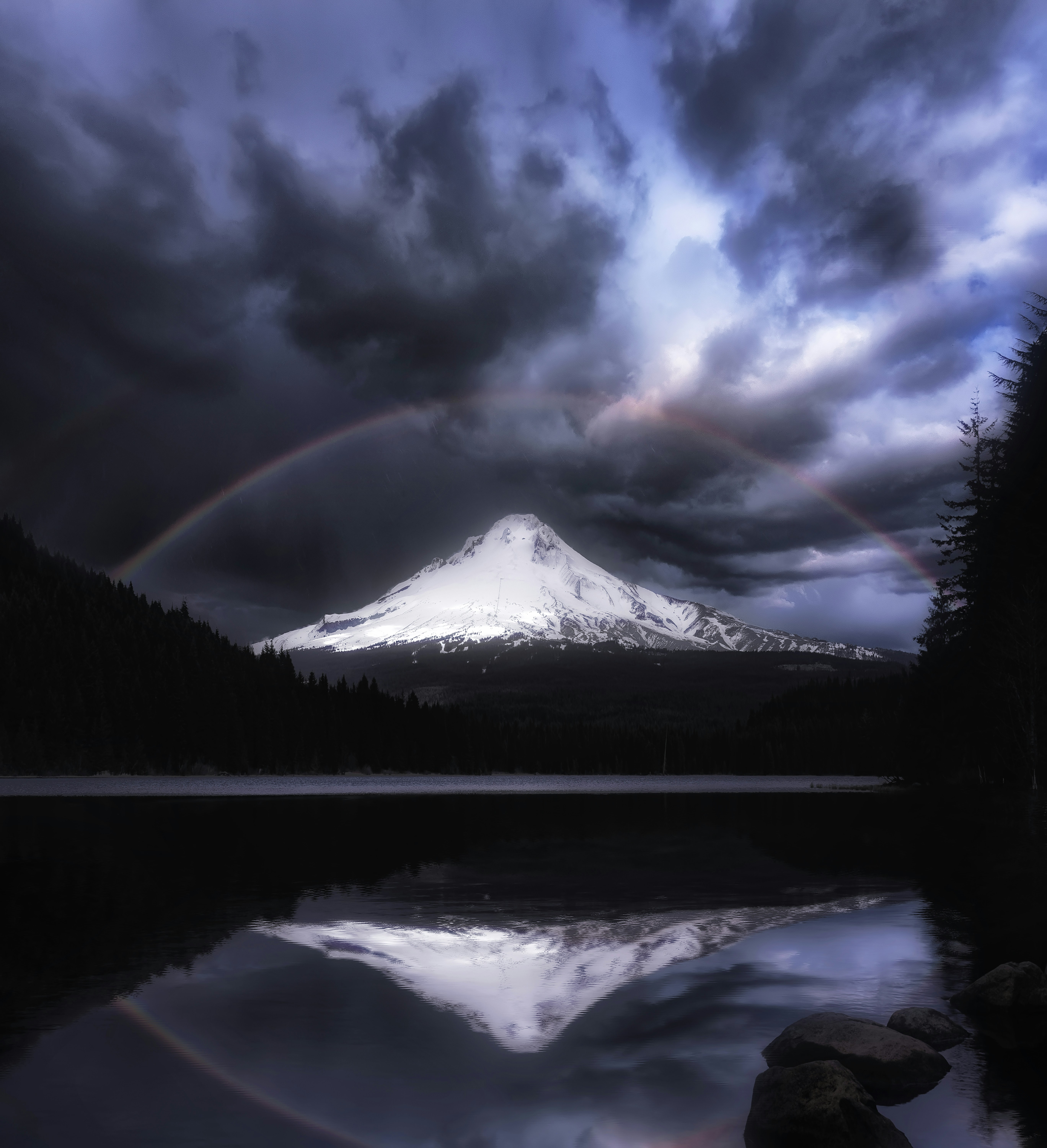 A mountain with a rainbow in the sky