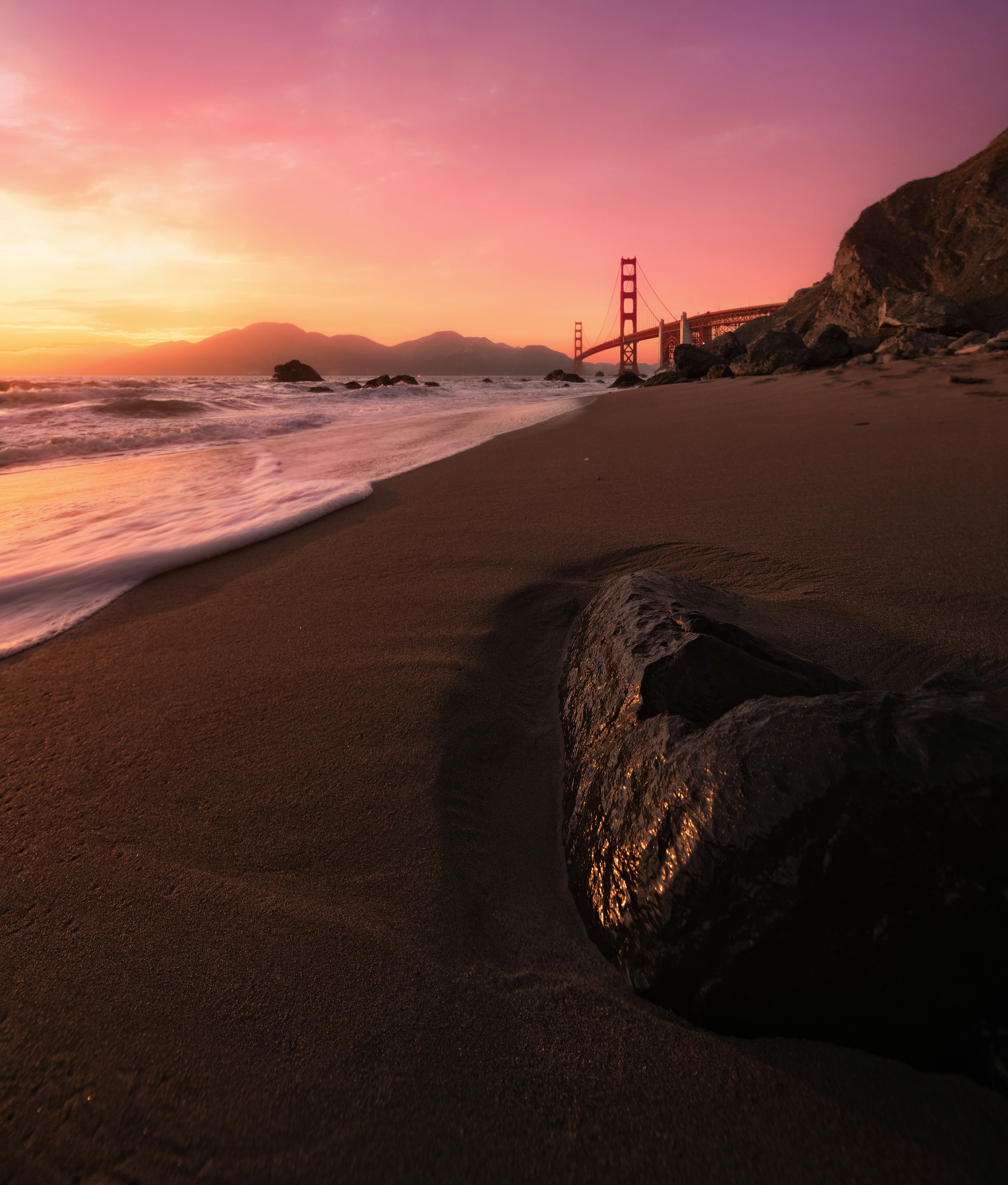 A sunset view of the golden gate bridge from the beach