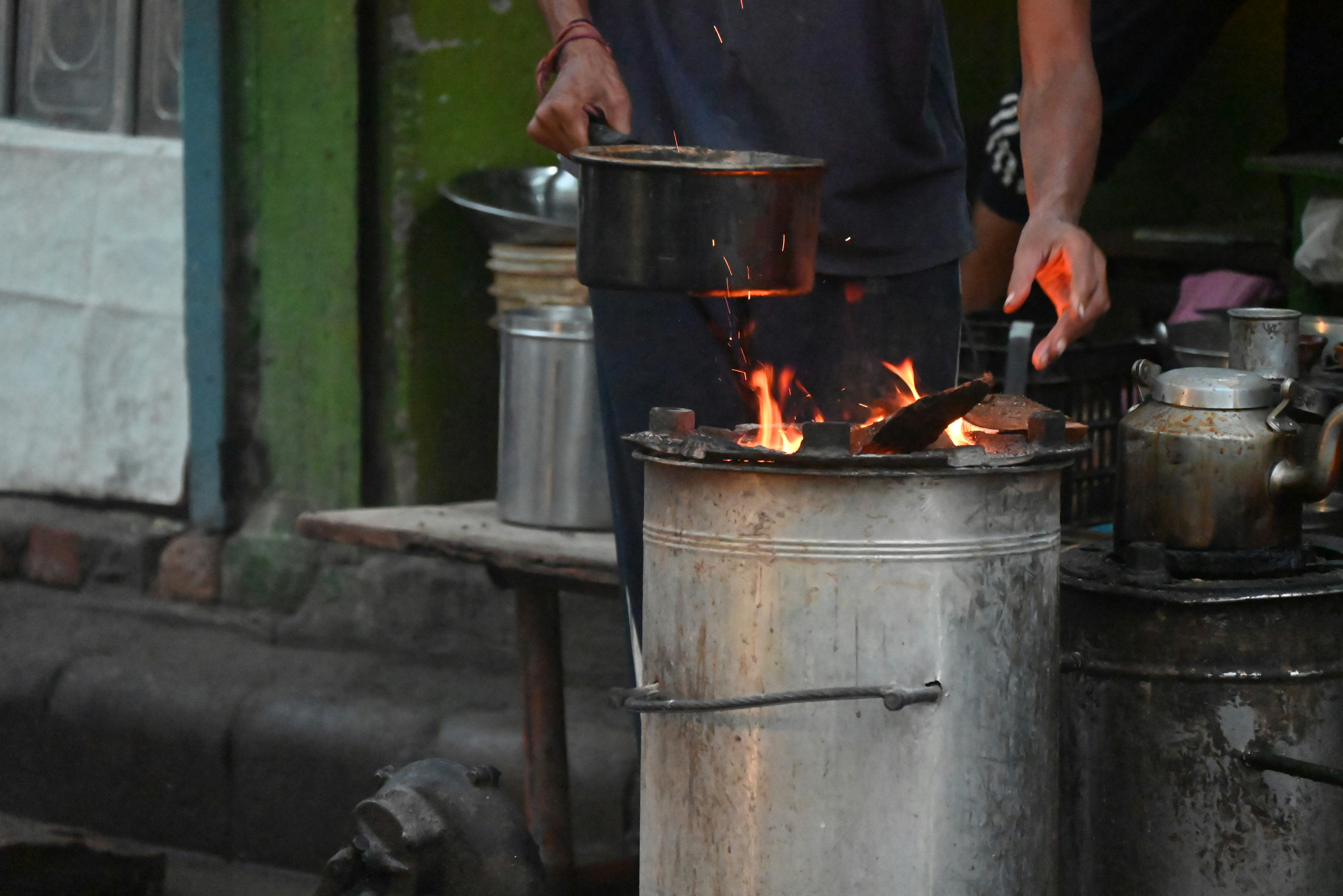 A man standing over a pot on top of a stove