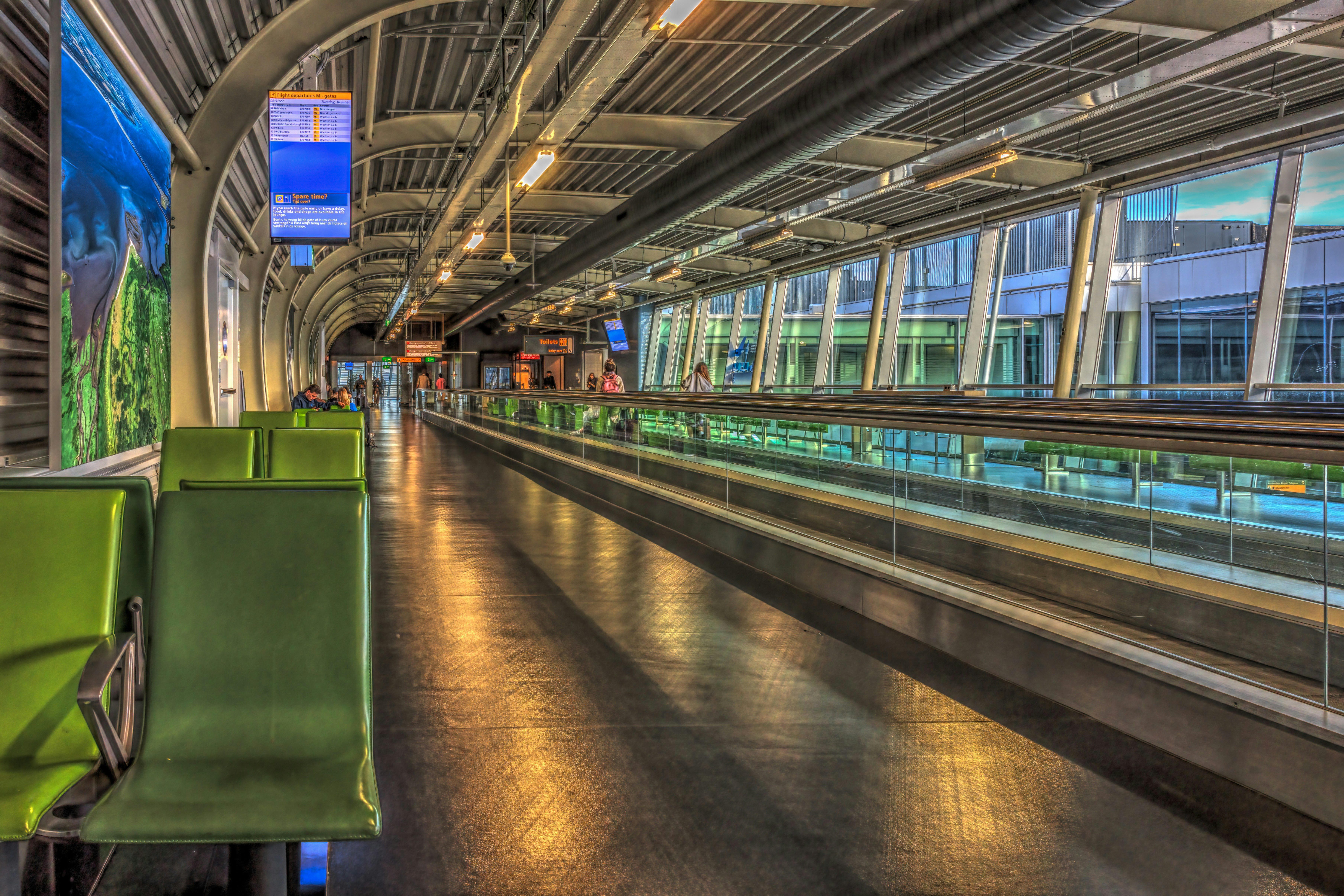 A green chair sitting in a train station, 