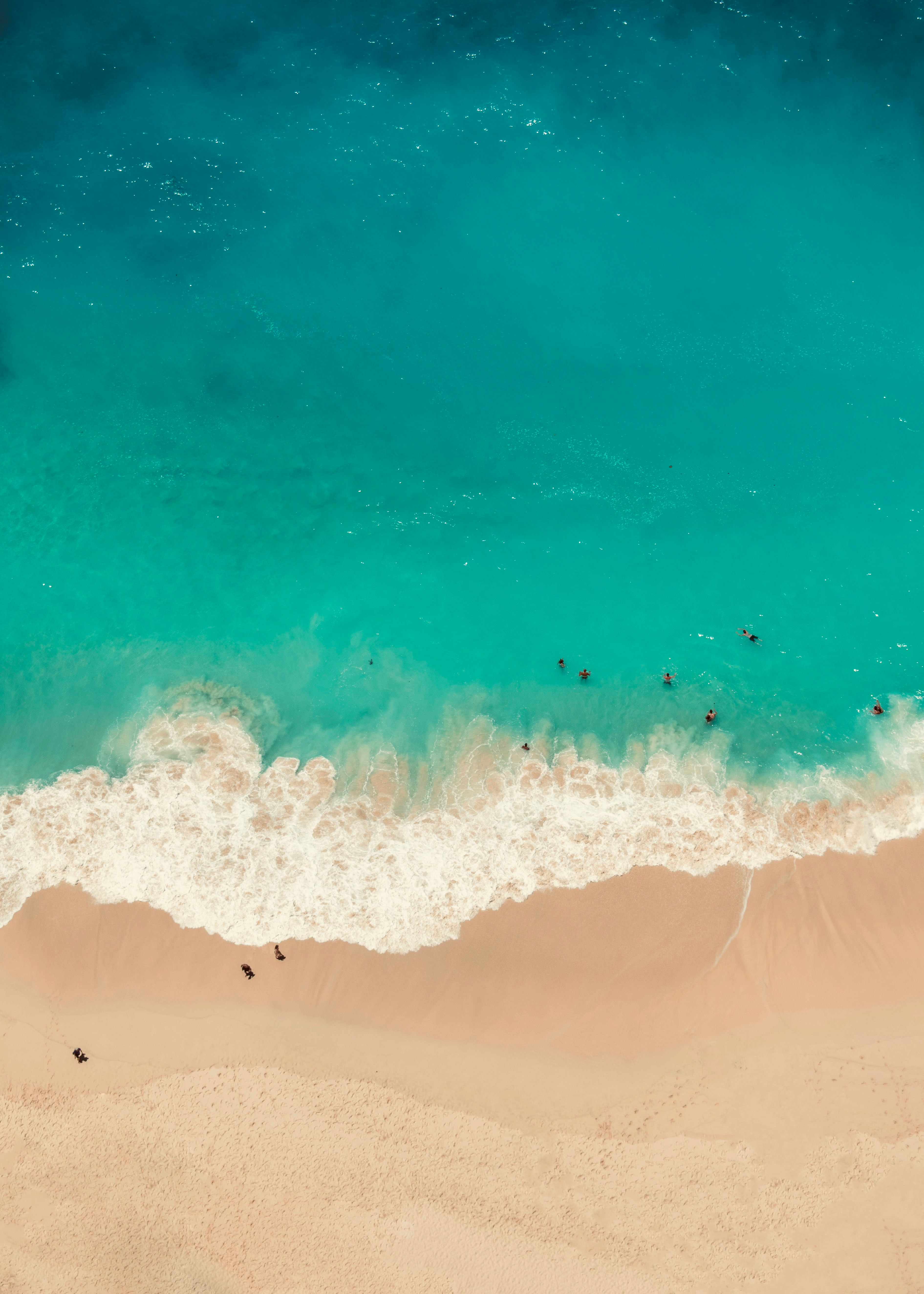 An aerial view of a beach with people in the water