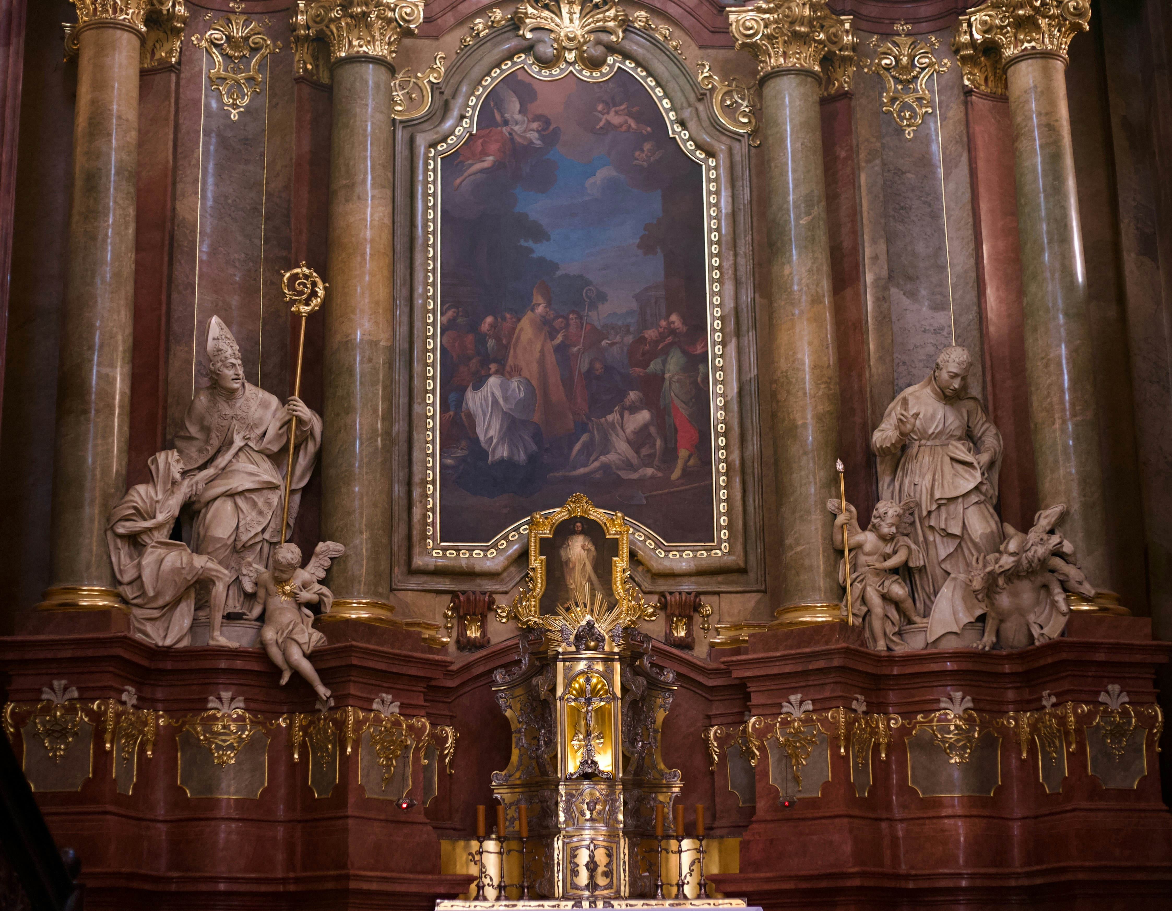A church alter with a painting on the wall
