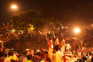 A crowd of people standing around a street at night