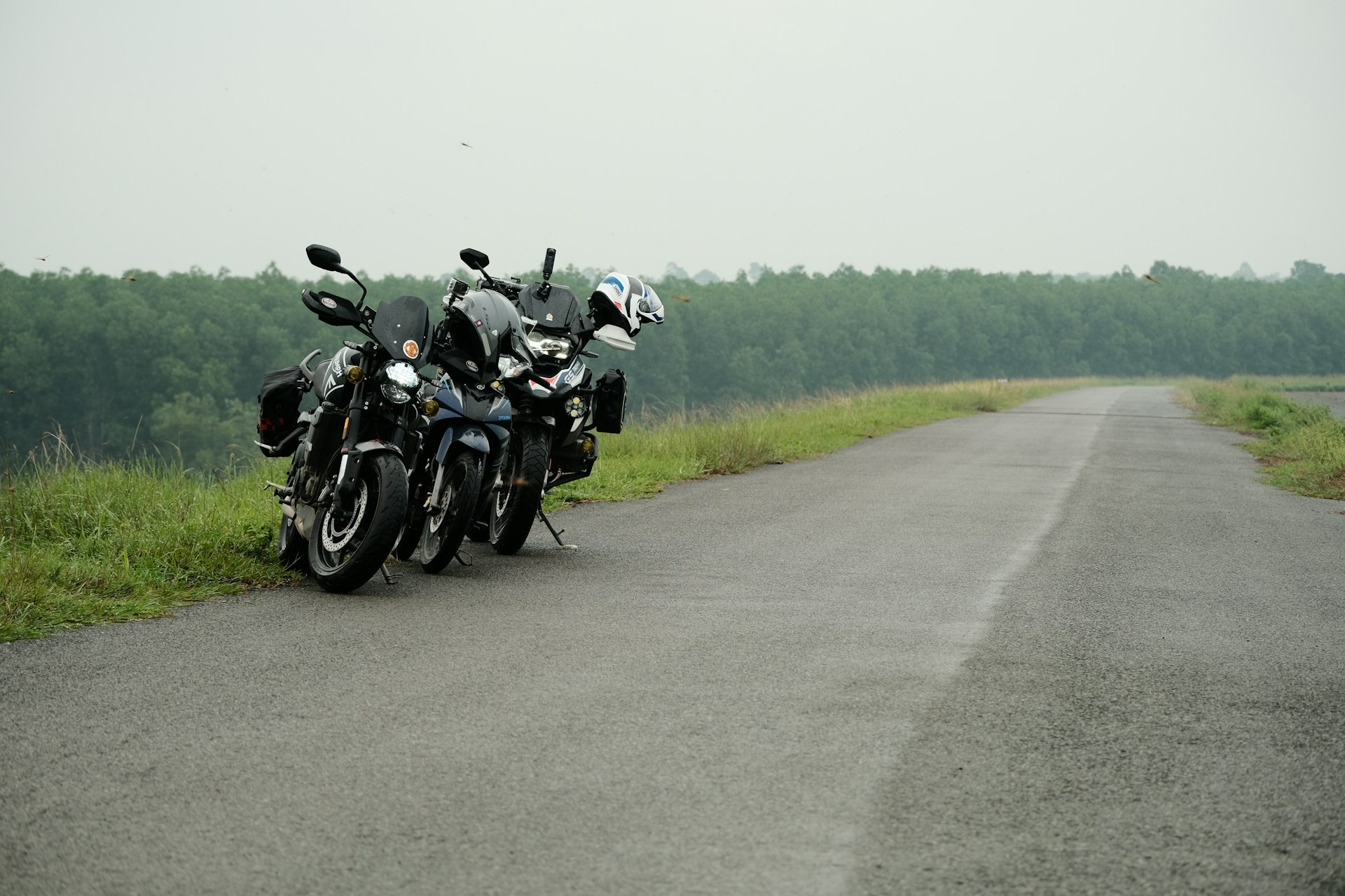 Two motorcycles are parked on the side of the road
