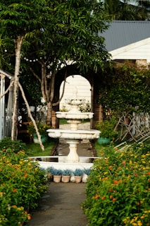 A garden with a fountain surrounded by flowers
