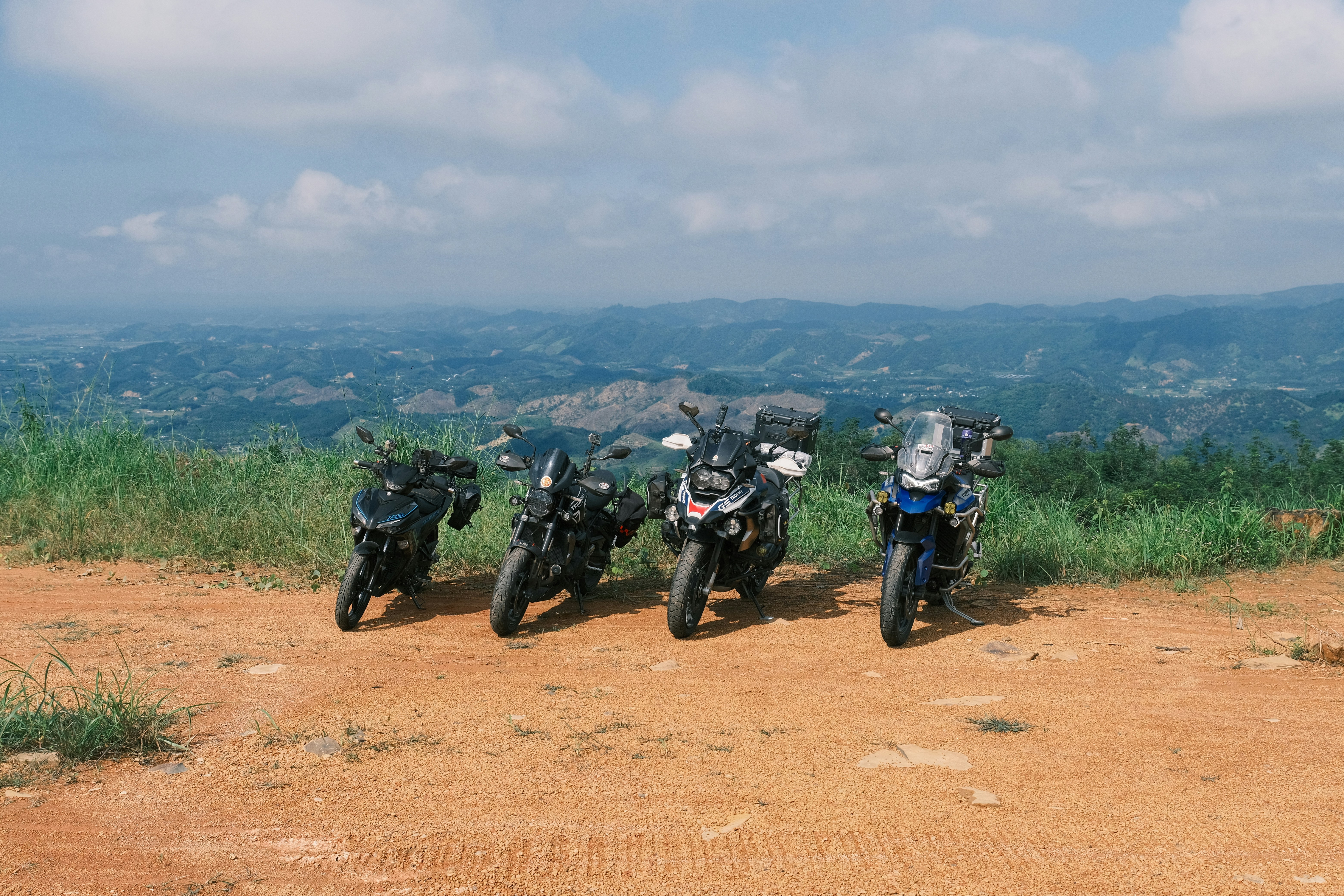 A group of motorcycles parked on a dirt road